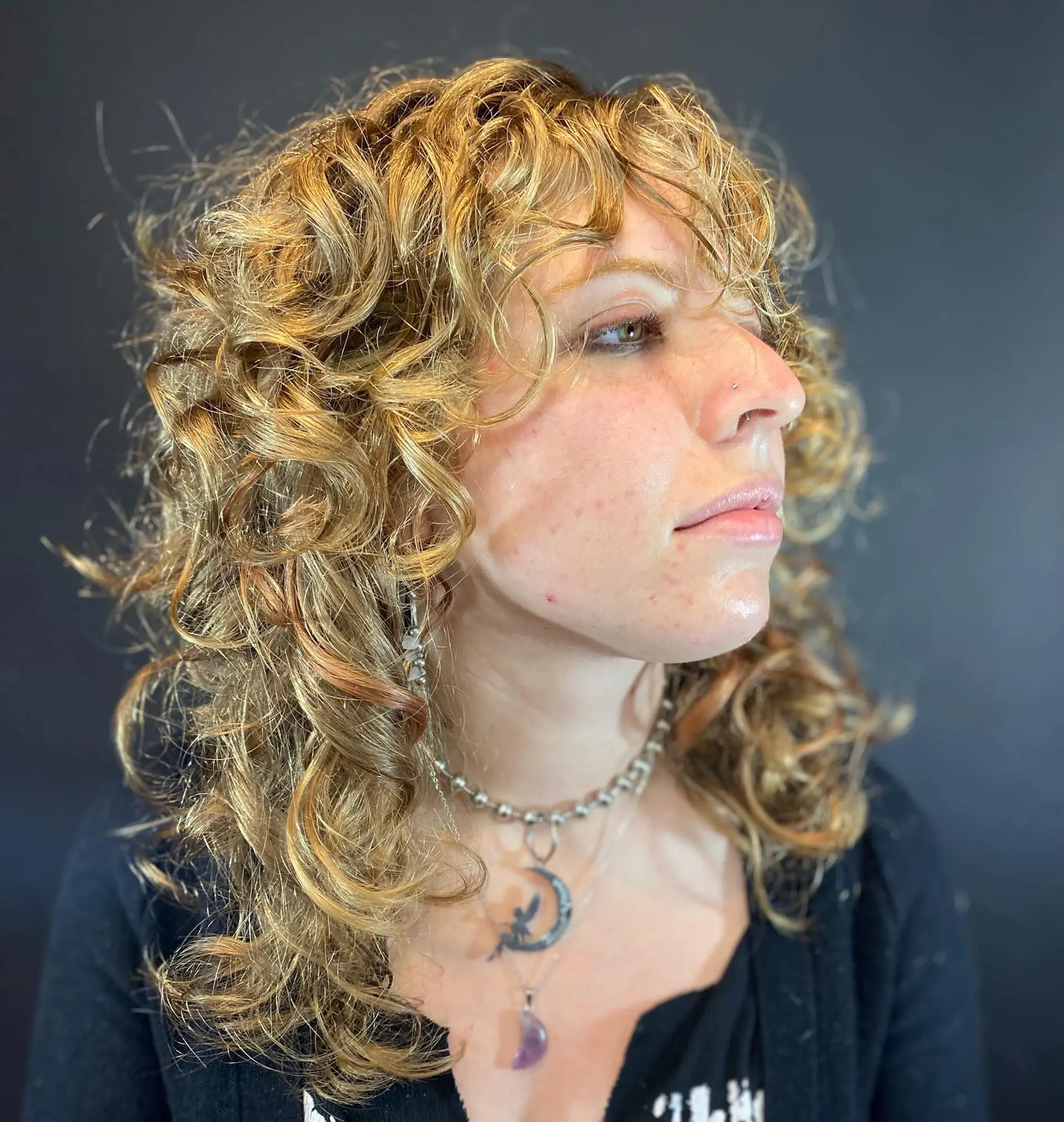 Medium-length curly shag featuring layered texture, defined natural ringlets, and full curly bangs. 1