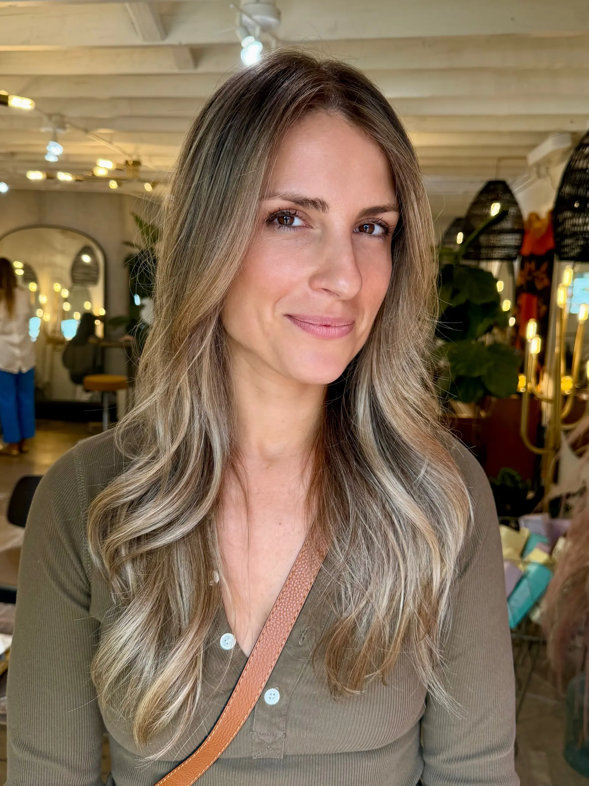 Long hair featuring dimensional blonde highlights blended into a soft brown base, styled in loose waves. 1
