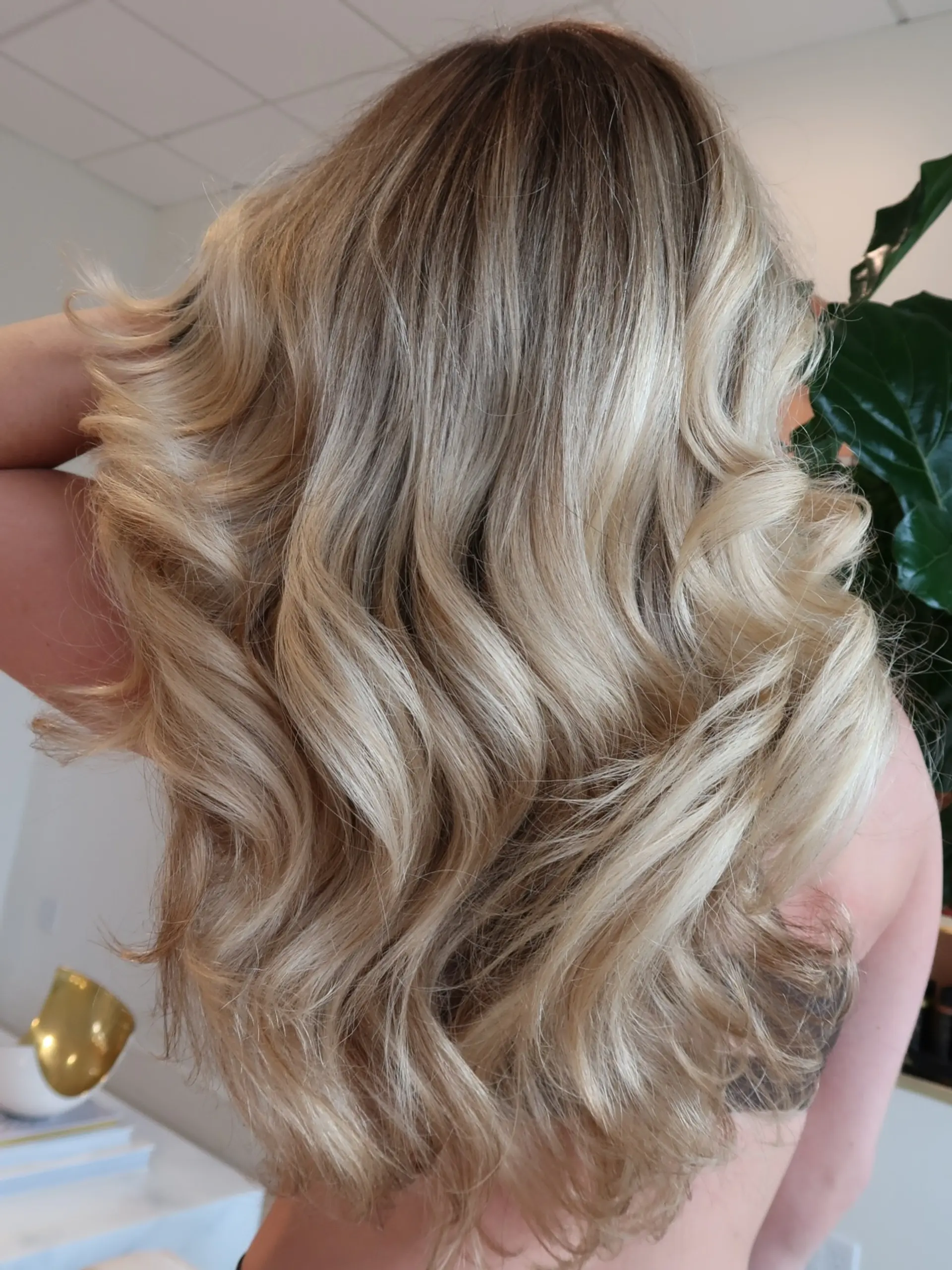 Long dimensional blonde hair styled into smooth, voluminous waves with a soft blowout finish. 1