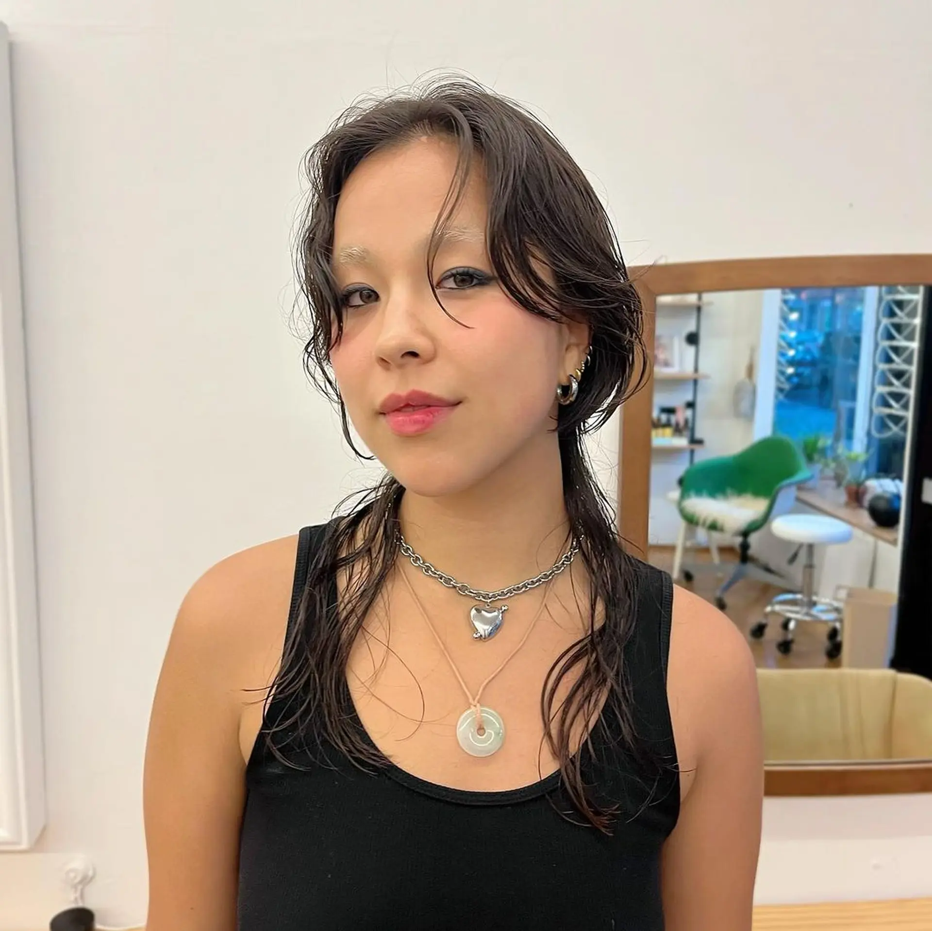 A medium-length hairstyle featuring a wet look with loose waves and face-framing layers, parted in the middle. The dark brown to black hair has a natural shine and texture, creating a relaxed yet stylish appearance. @asianbabygangster 1