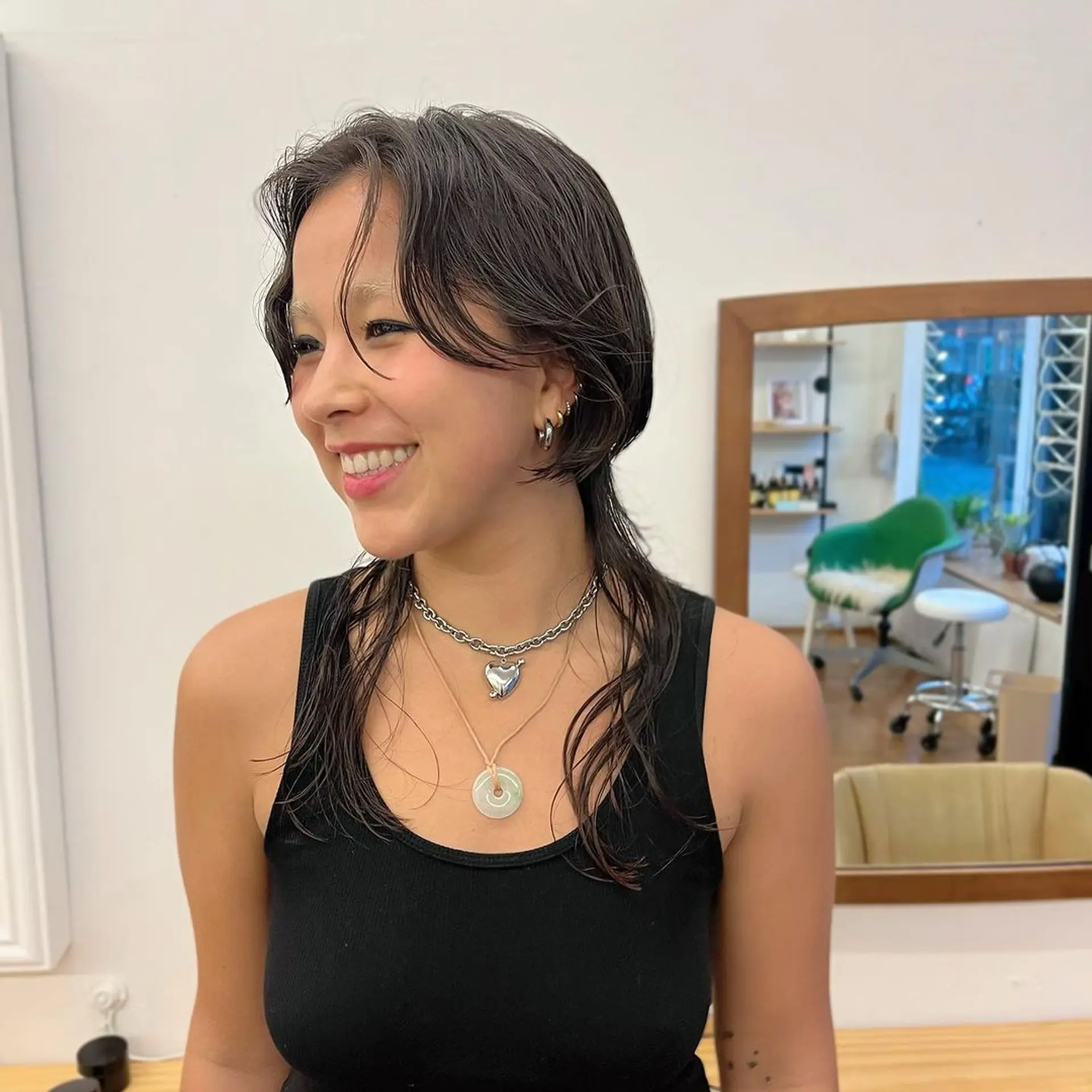 A medium-length hairstyle featuring a wet look with loose waves and face-framing layers, parted in the middle. The dark brown to black hair has a natural shine and texture, creating a relaxed yet stylish appearance. @asianbabygangster 2