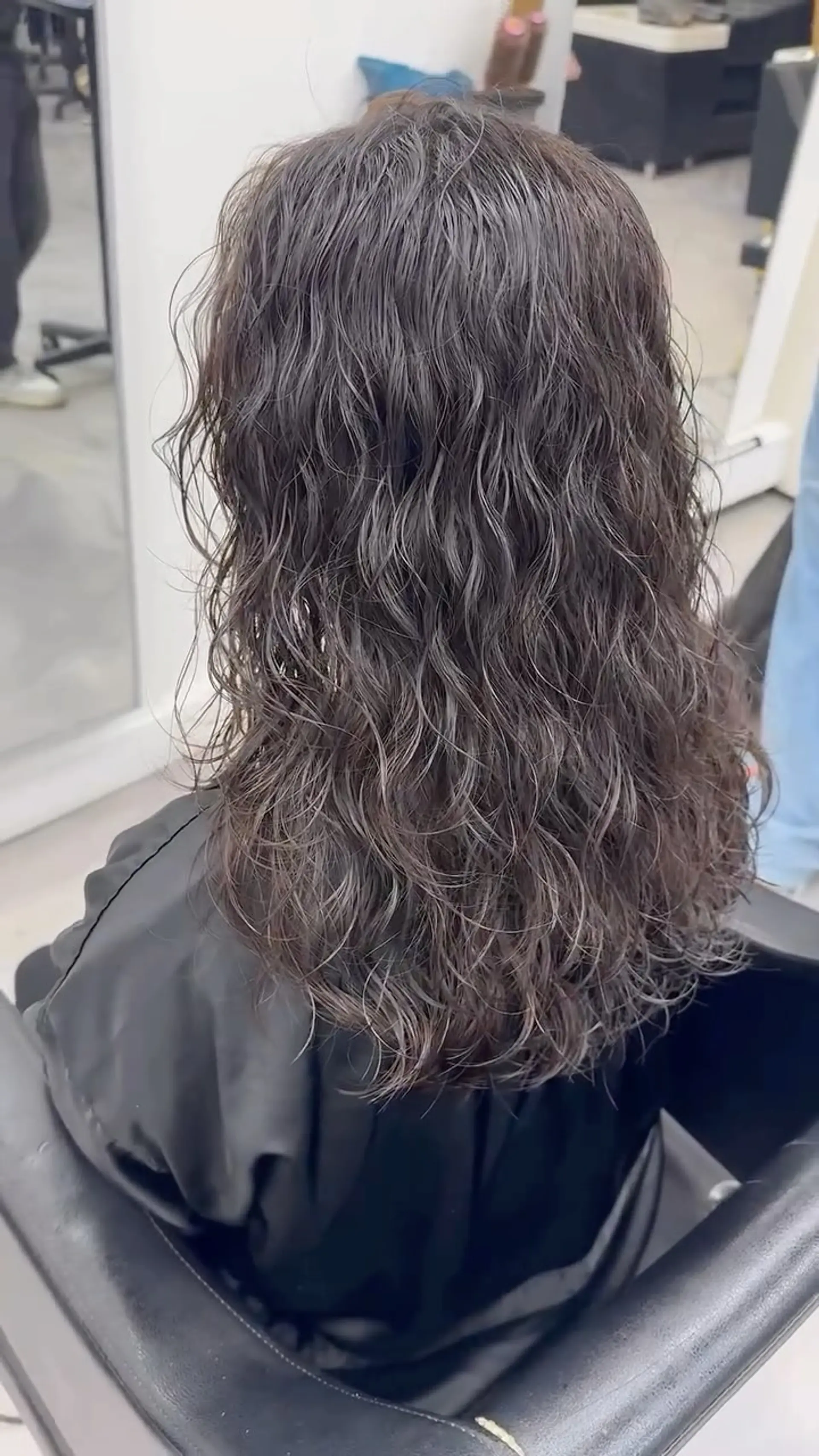 Mid-length dark hair styled with tousled, cascading textured waves and defined curls. 1