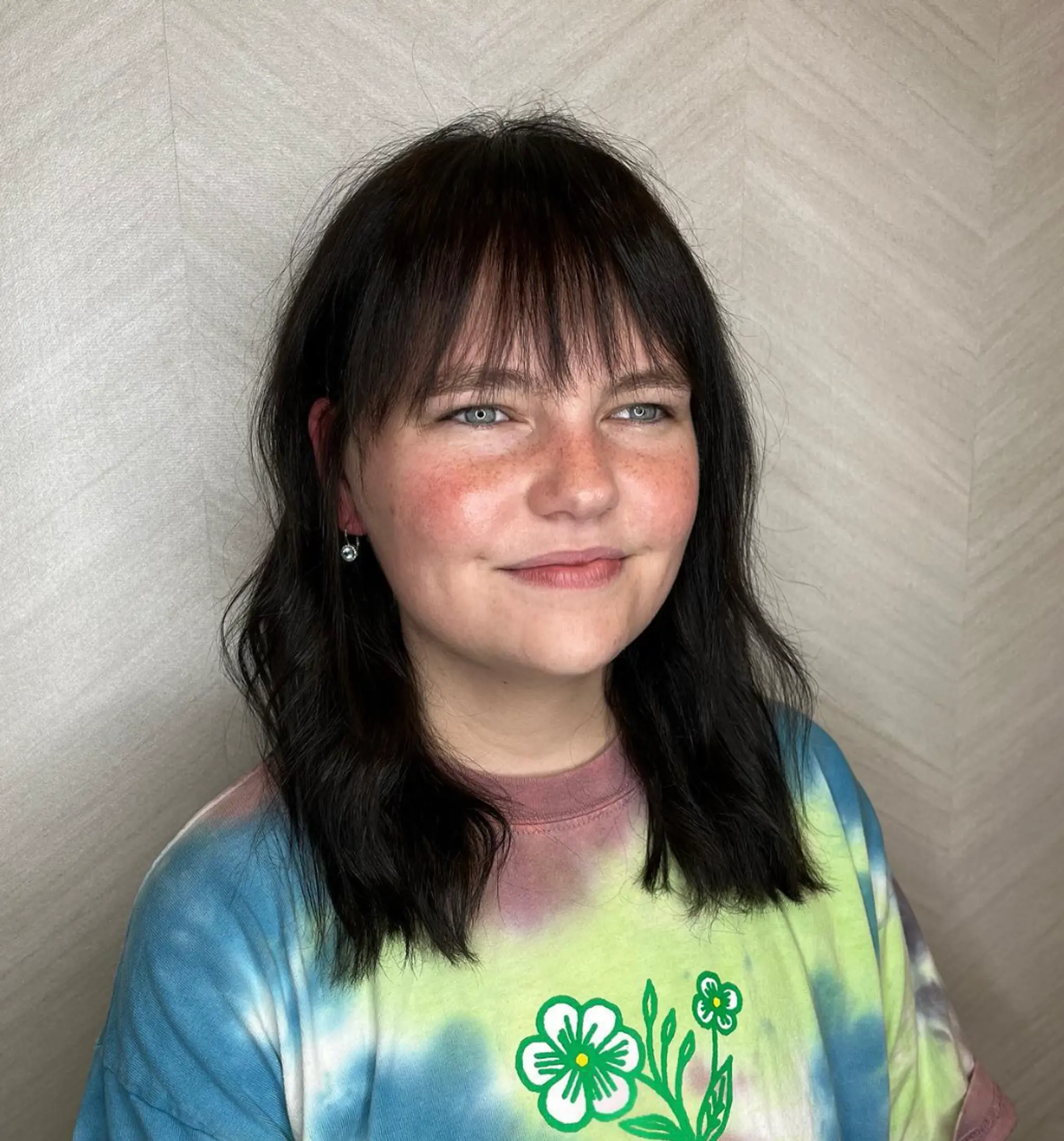 Medium-length, naturally wavy black hair with soft, wispy bangs that graze the eyebrows. The waves create a textured and relaxed look, reaching just below the shoulders.

Cut and style by @juliamannino_hair
Color by @simabeautynyc
