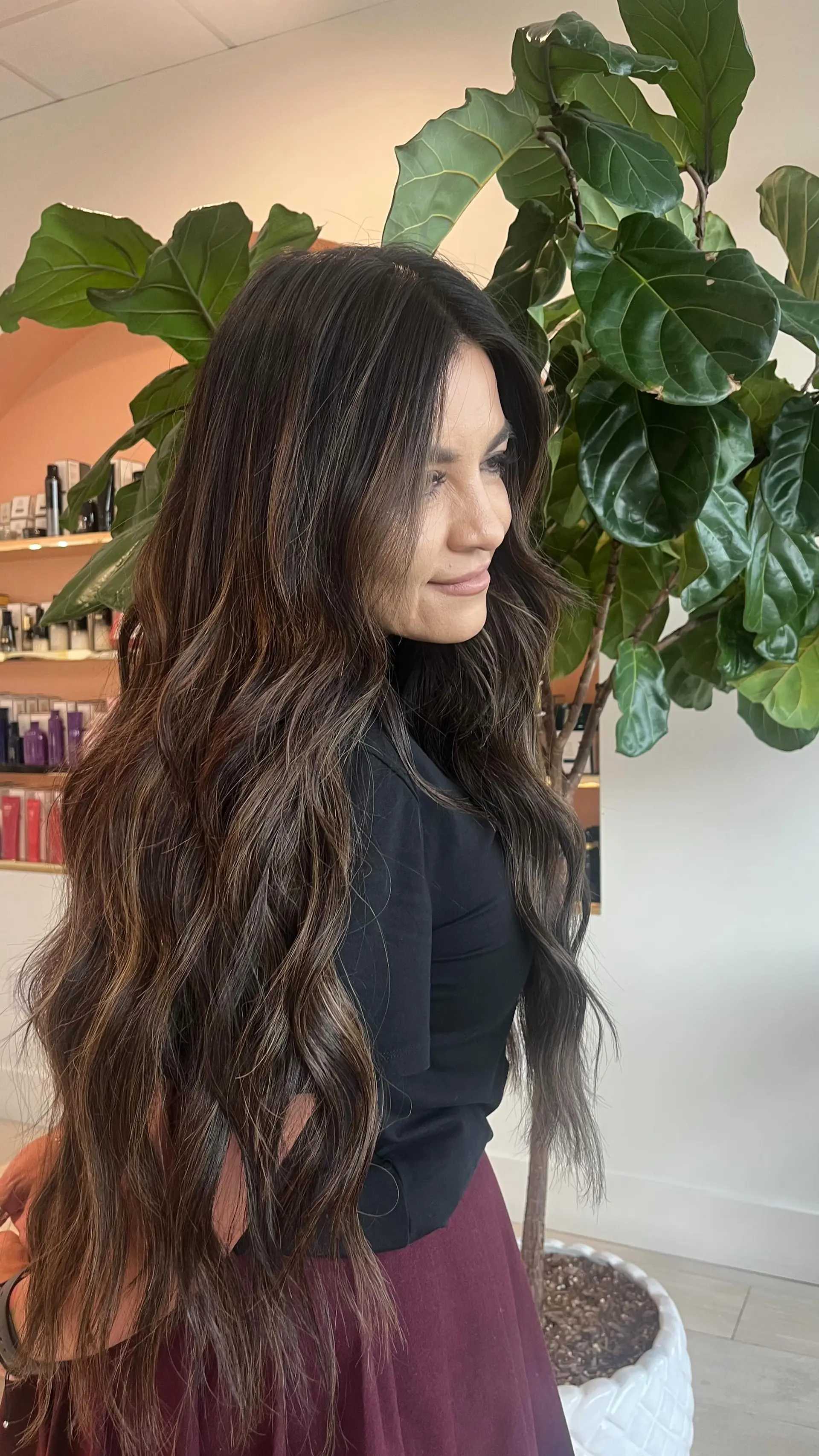 Extra-long dimensional brunette hair enhanced with extensions and styled into loose, flowing waves. 1