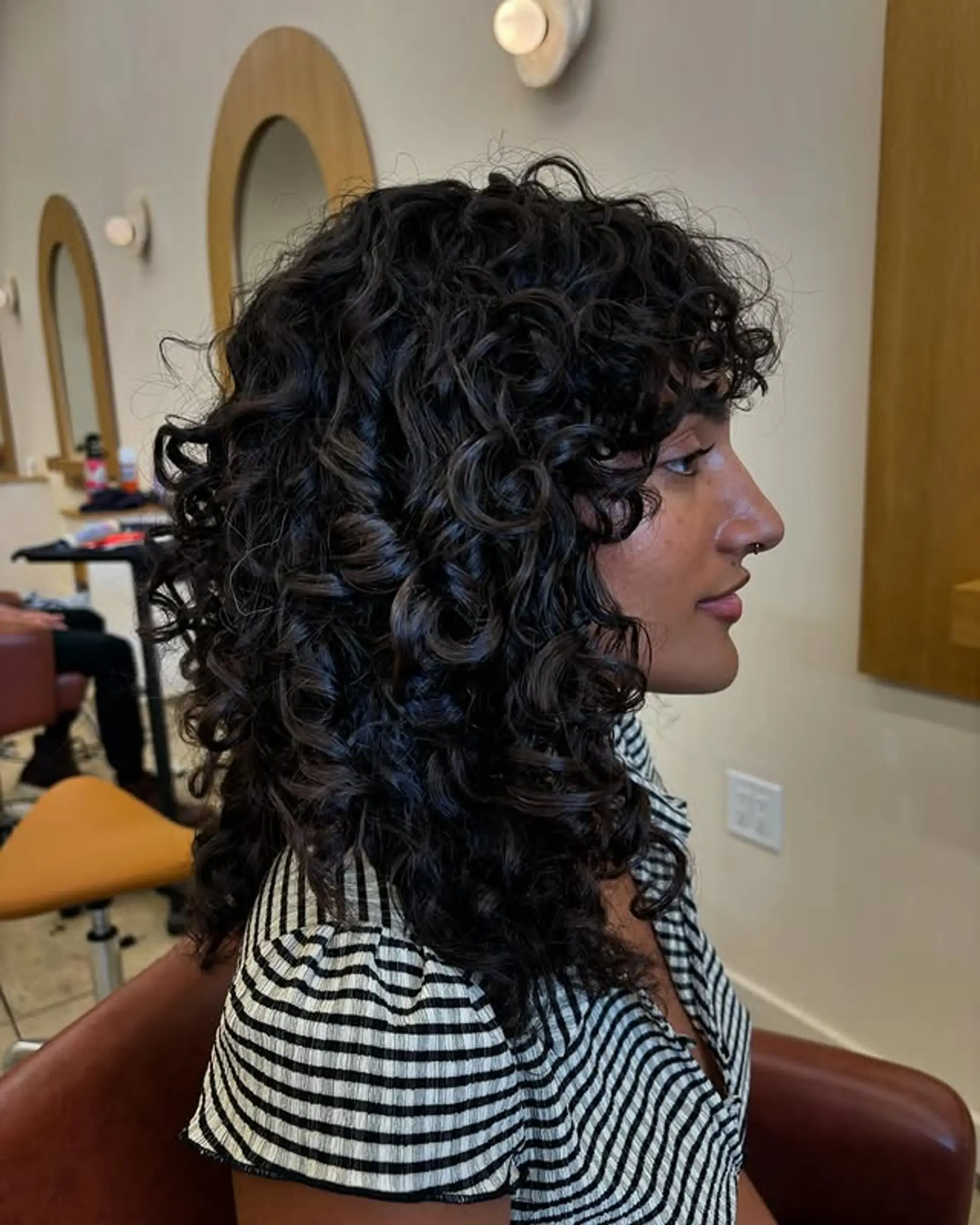 This is a shag haircut with bangs, ideal for curly hair. 1