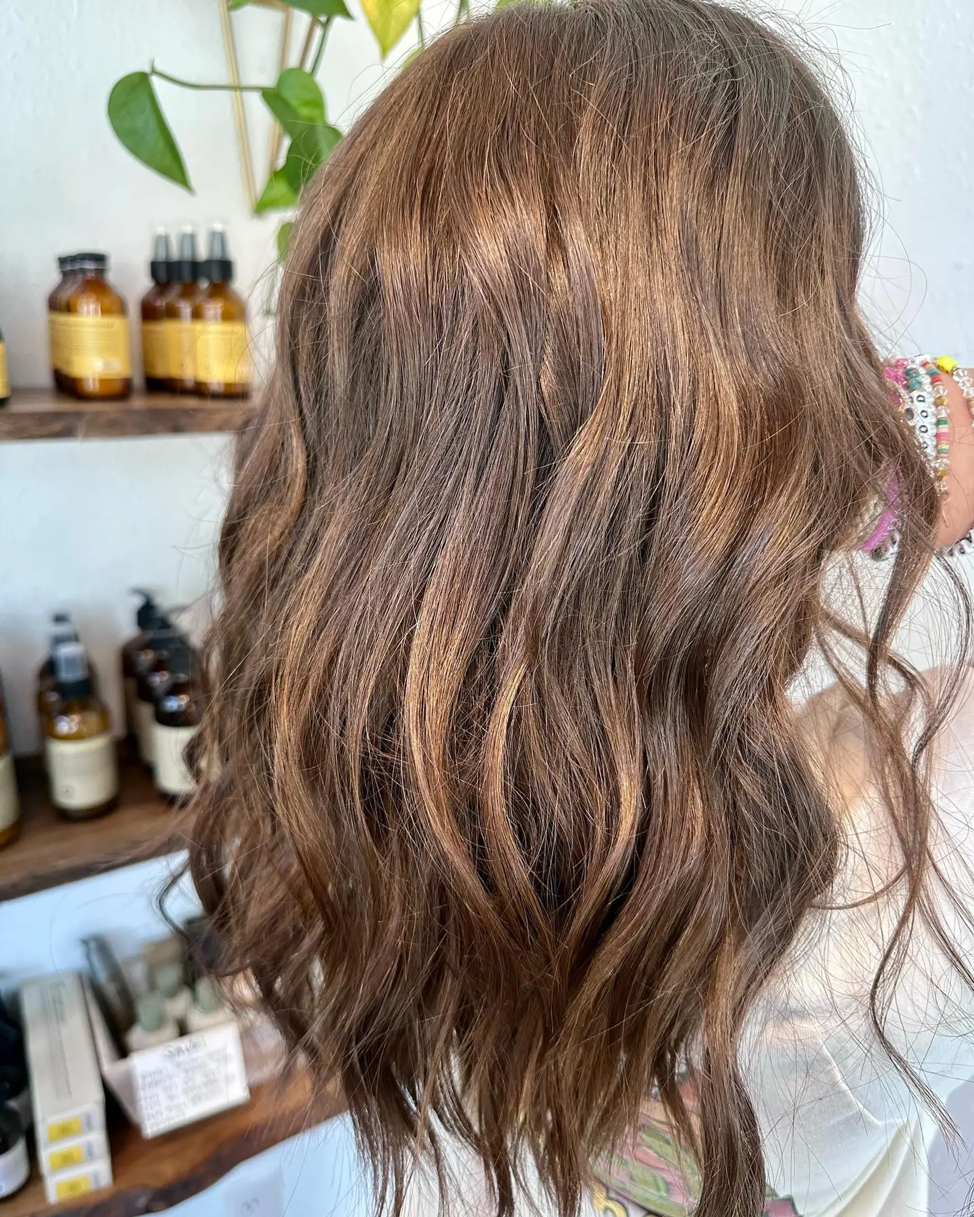 Medium-to-long soft brunette waves enhanced with seamlessly blended milk chocolate and caramel balayage highlights. 1