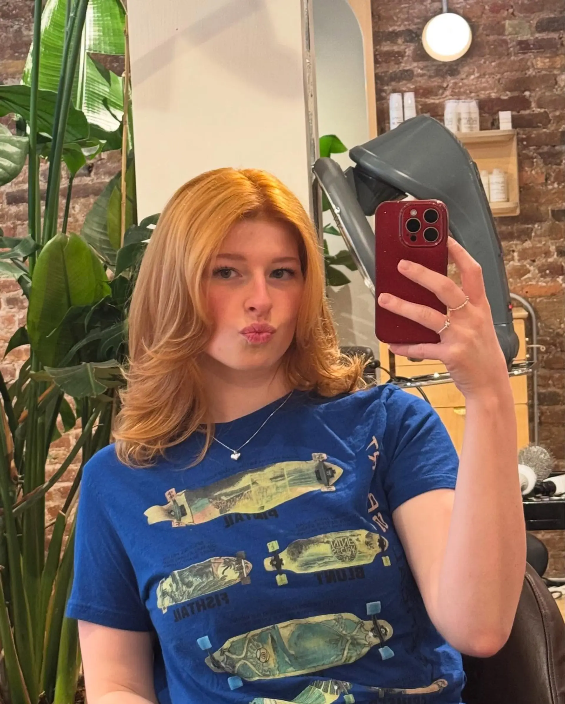 Medium-length natural strawberry copper layered haircut styled with a voluminous, flipped blowout. 1