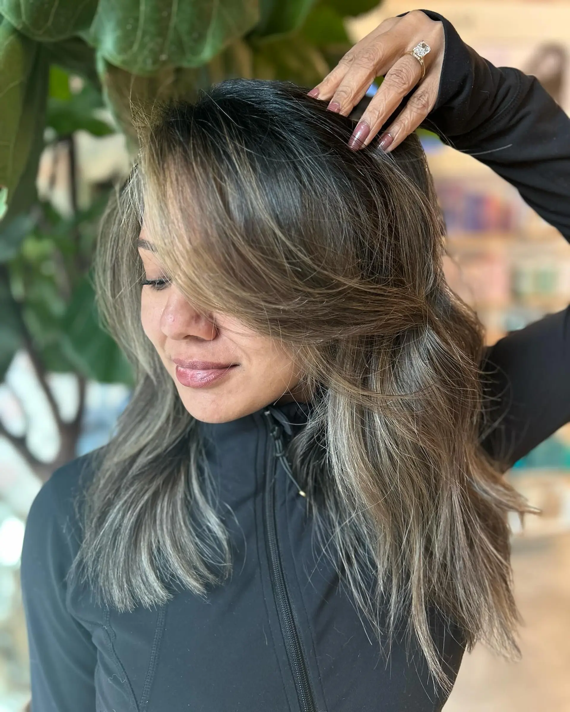 A dimensional cool-toned mushroom bronde reverse balayage paired with soft, textured face-framing layers. 1