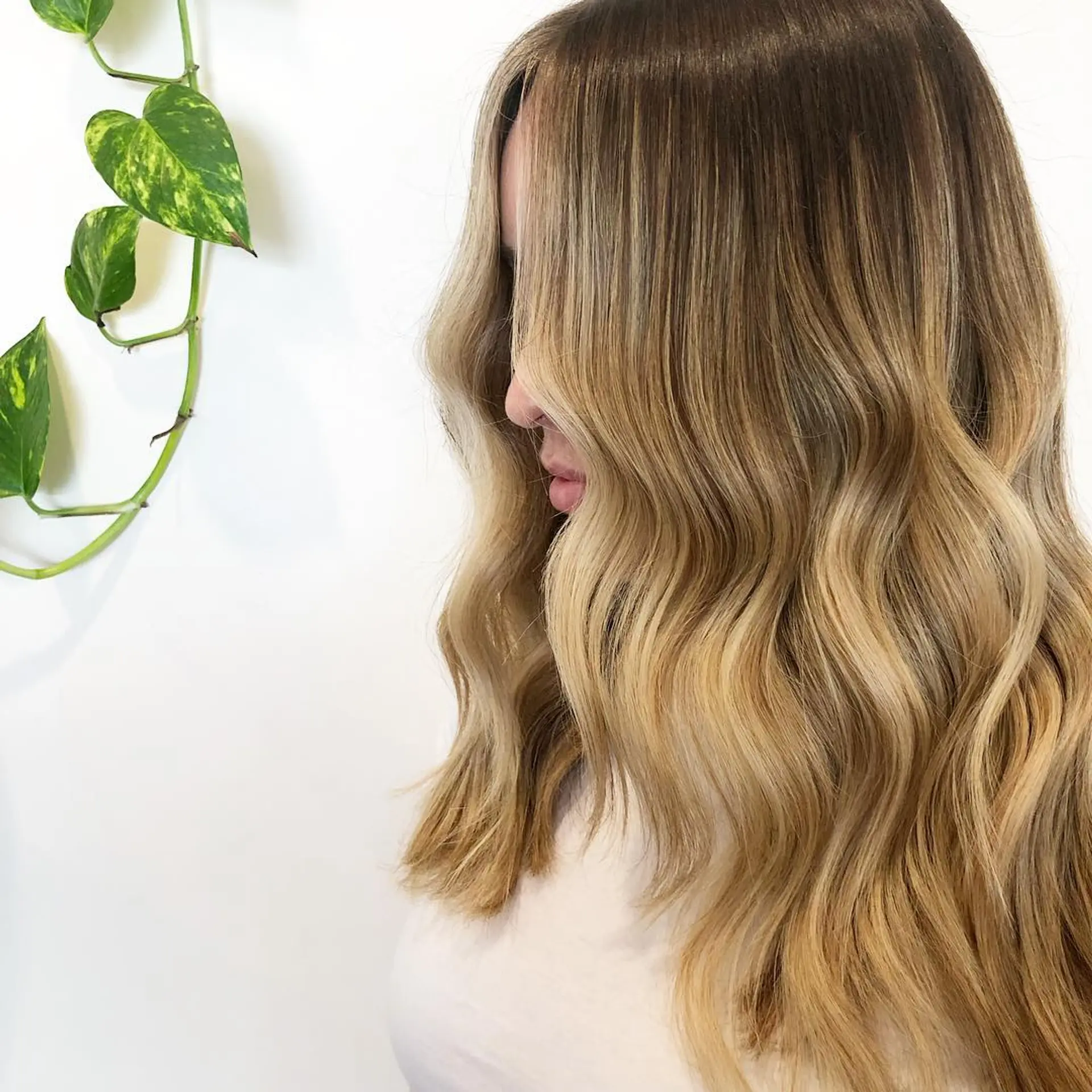 Long hair styled in soft, brushed-out waves featuring a warm golden blonde balayage with a shadowed root. 1
