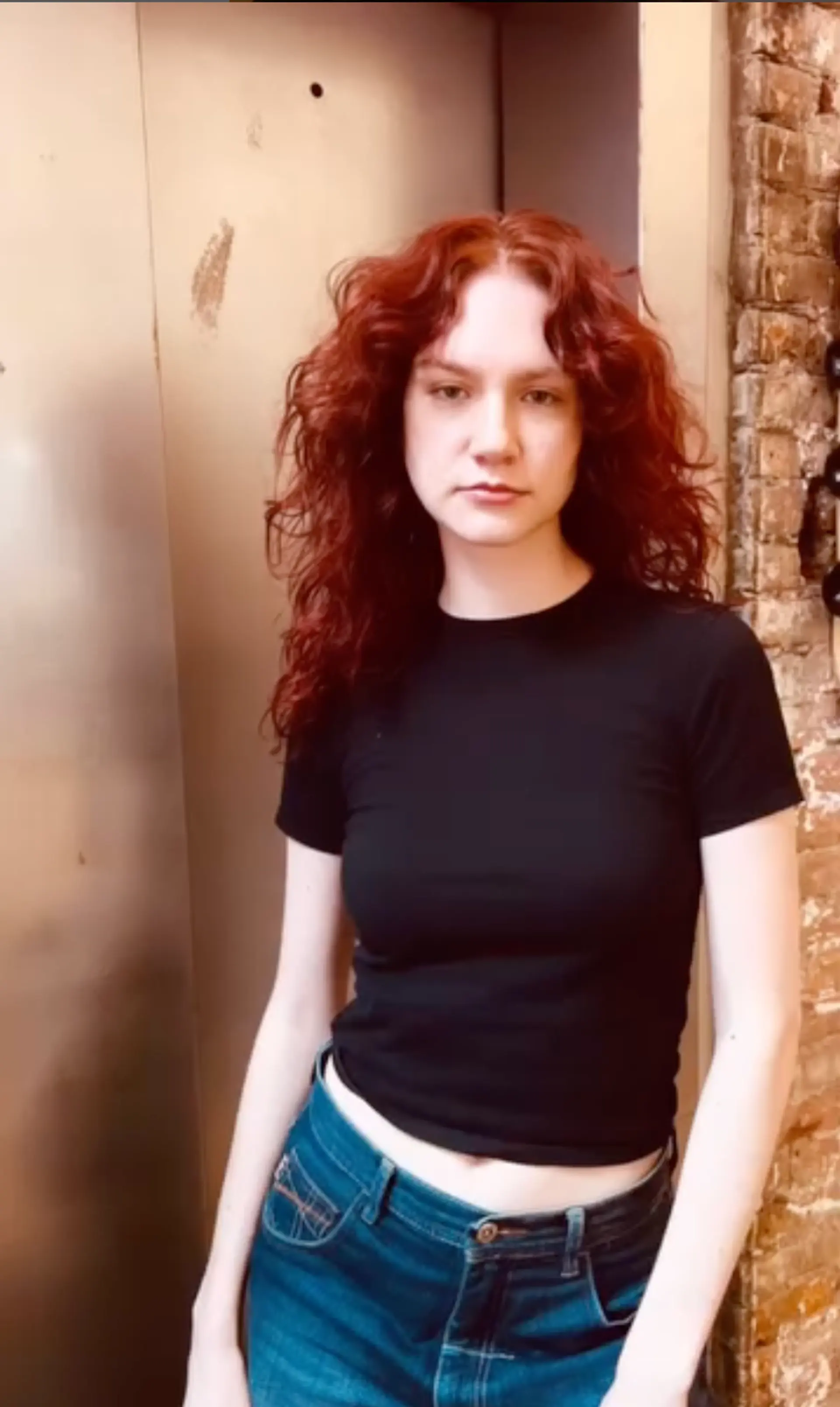 This long, wavy hairstyle features voluminous, natural waves cascading down past the shoulders, with a vibrant red color that stands out. The hairstyle is layered to enhance the wavy texture, providing a lively and dynamic look. 1