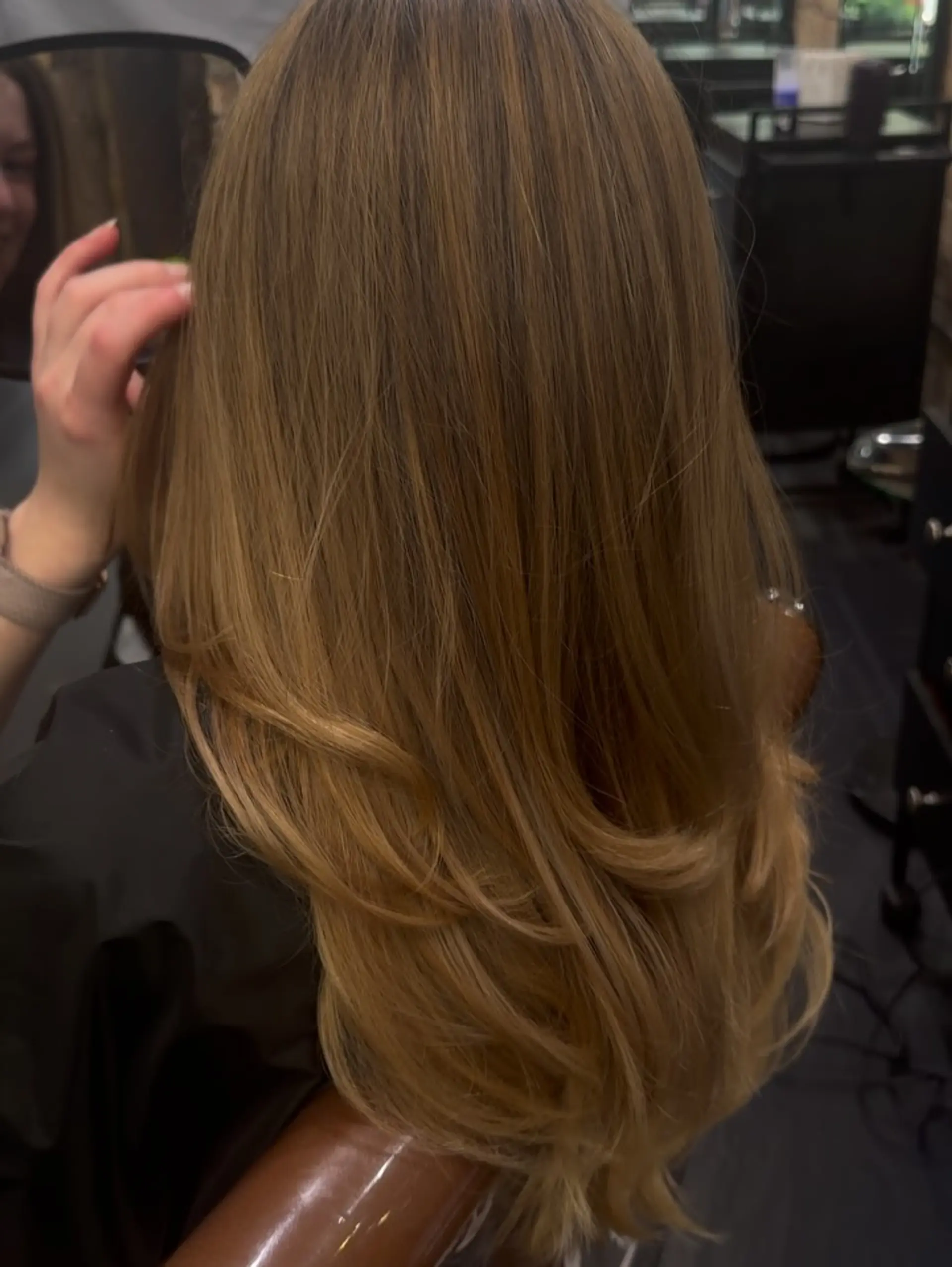 Long warm honey blonde hair styled in smooth, flowing layers with soft curved ends. 1