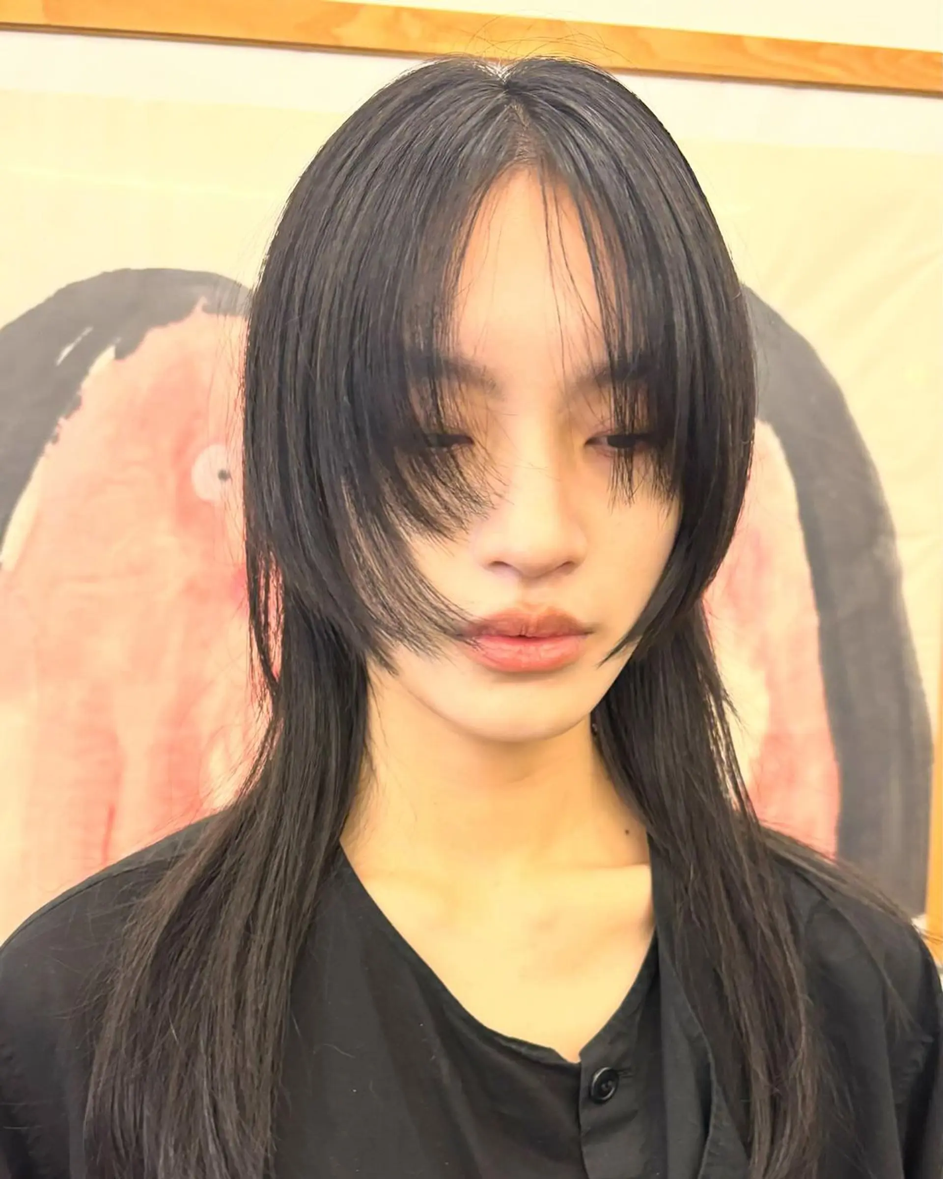Jet black, straight hair with medium length and layered bangs, featuring feathered layers and a face-framing, edgy look. 1