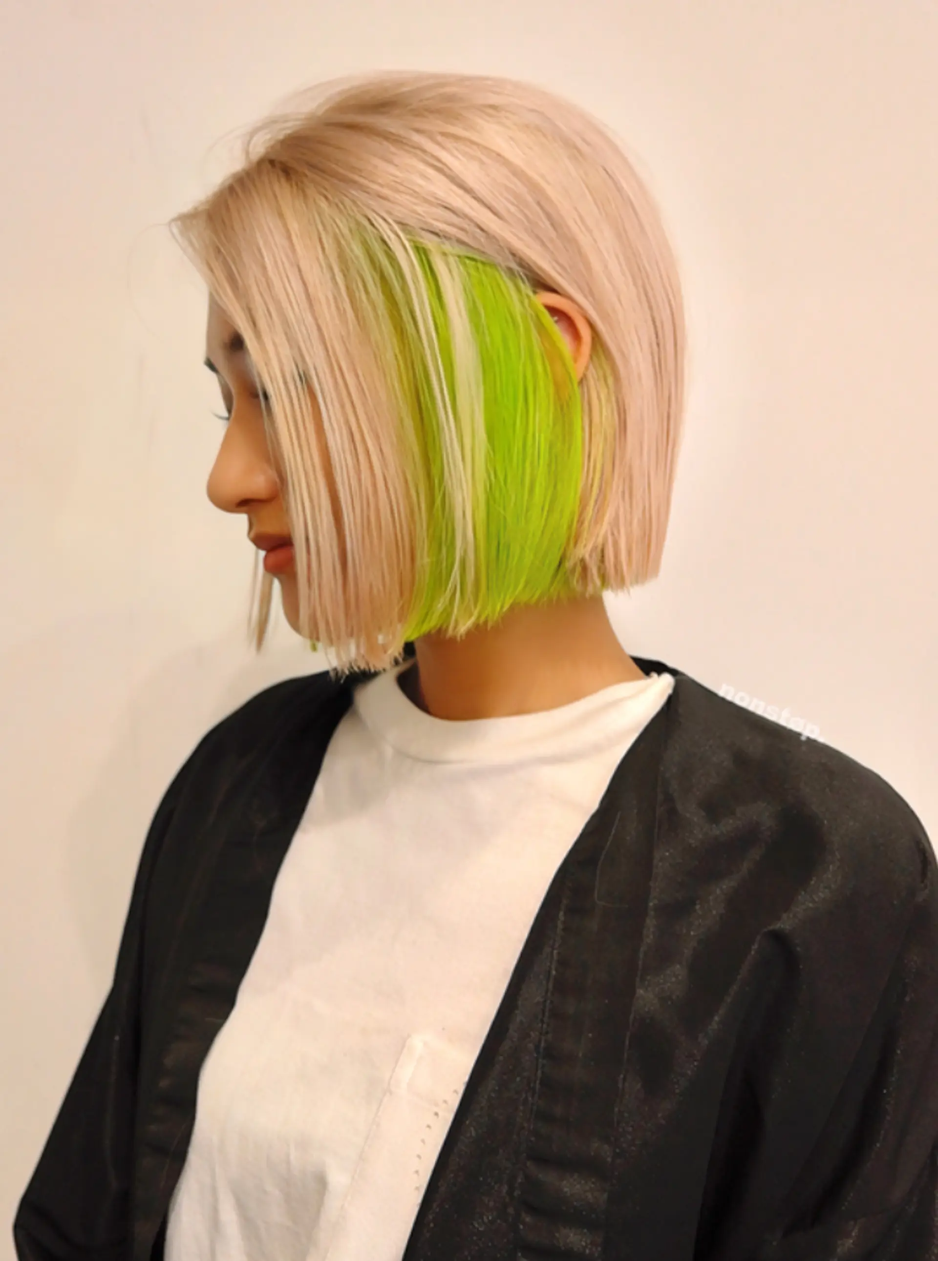 A short, straight bob cut with blunt edges, featuring a striking contrast between platinum blonde on the top layer and a vivid neon green underlayer, creating a sleek and edgy look.

(NonstopStyle: by Kelvin) 1