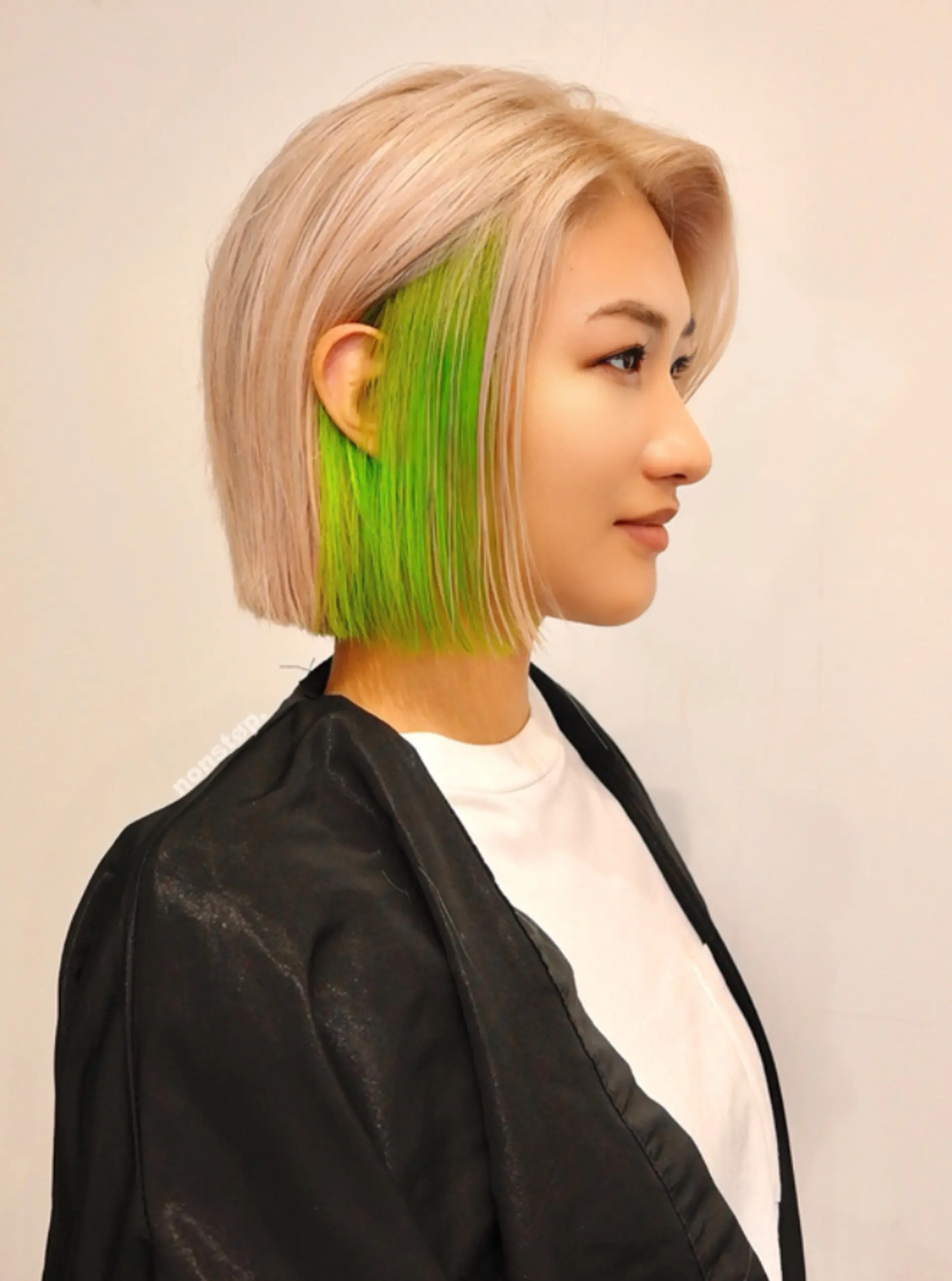 A short, straight bob cut with blunt edges, featuring a striking contrast between platinum blonde on the top layer and a vivid neon green underlayer, creating a sleek and edgy look.

(NonstopStyle: by Kelvin) 2