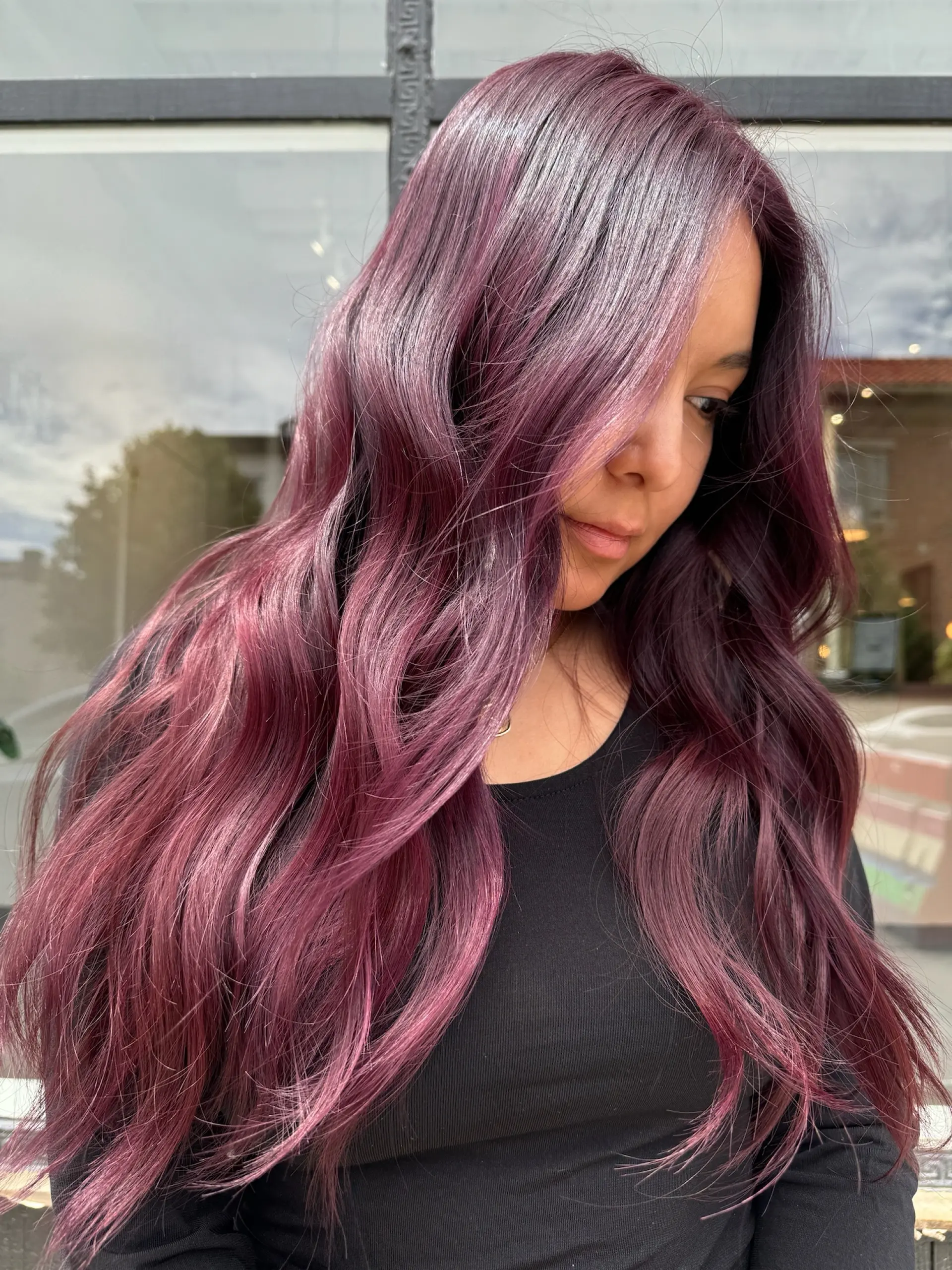 Long, glossy hair colored in a smoky plum and dusty violet tone styled with loose, flowing waves. 1