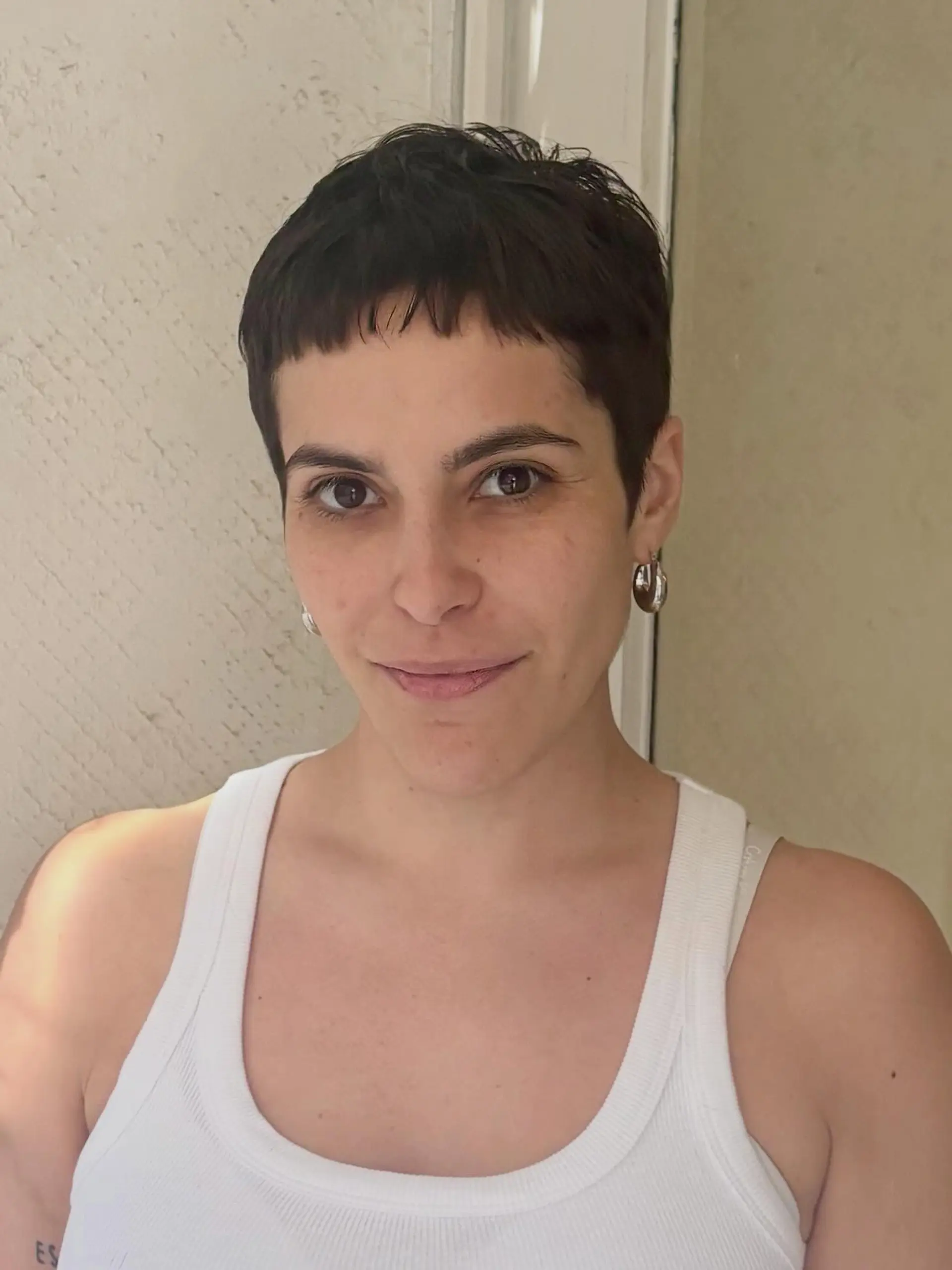 A soft, textured dark pixie crop featuring short, piecey micro bangs. 1