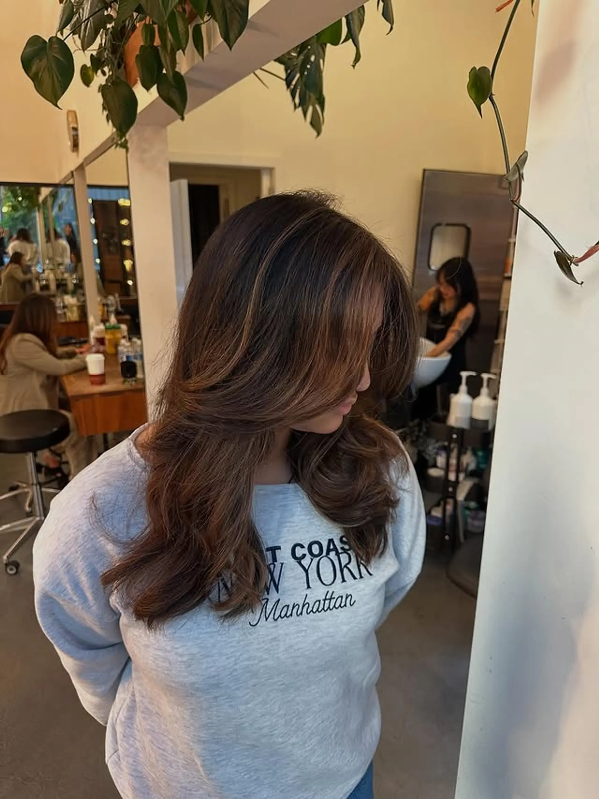 Long, layered hairstyle with soft waves and face-framing layers. 1