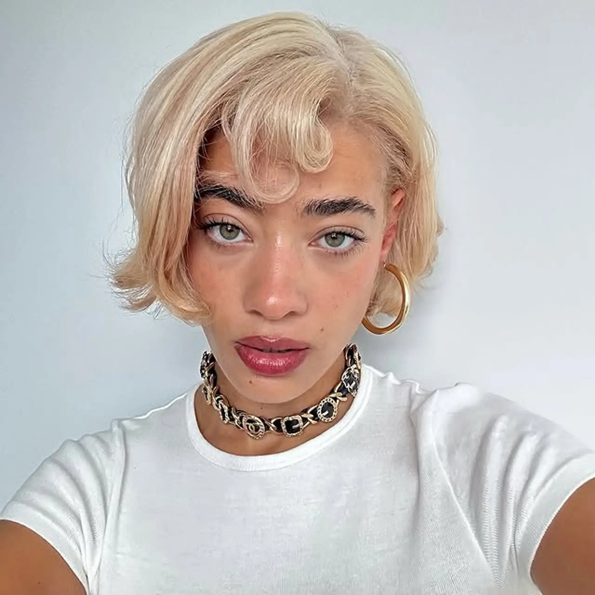 A short, wavy bob with a curled bang, reminiscent of vintage styles with a modern twist. 1