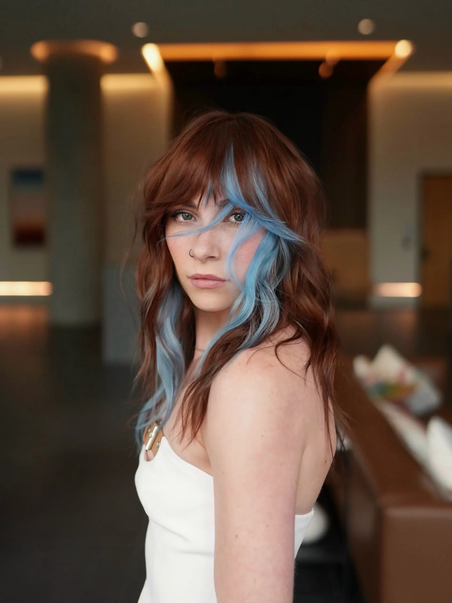 A layered, wavy shag cut with bangs showcasing a rich copper base and bold denim blue face-framing panels. 1