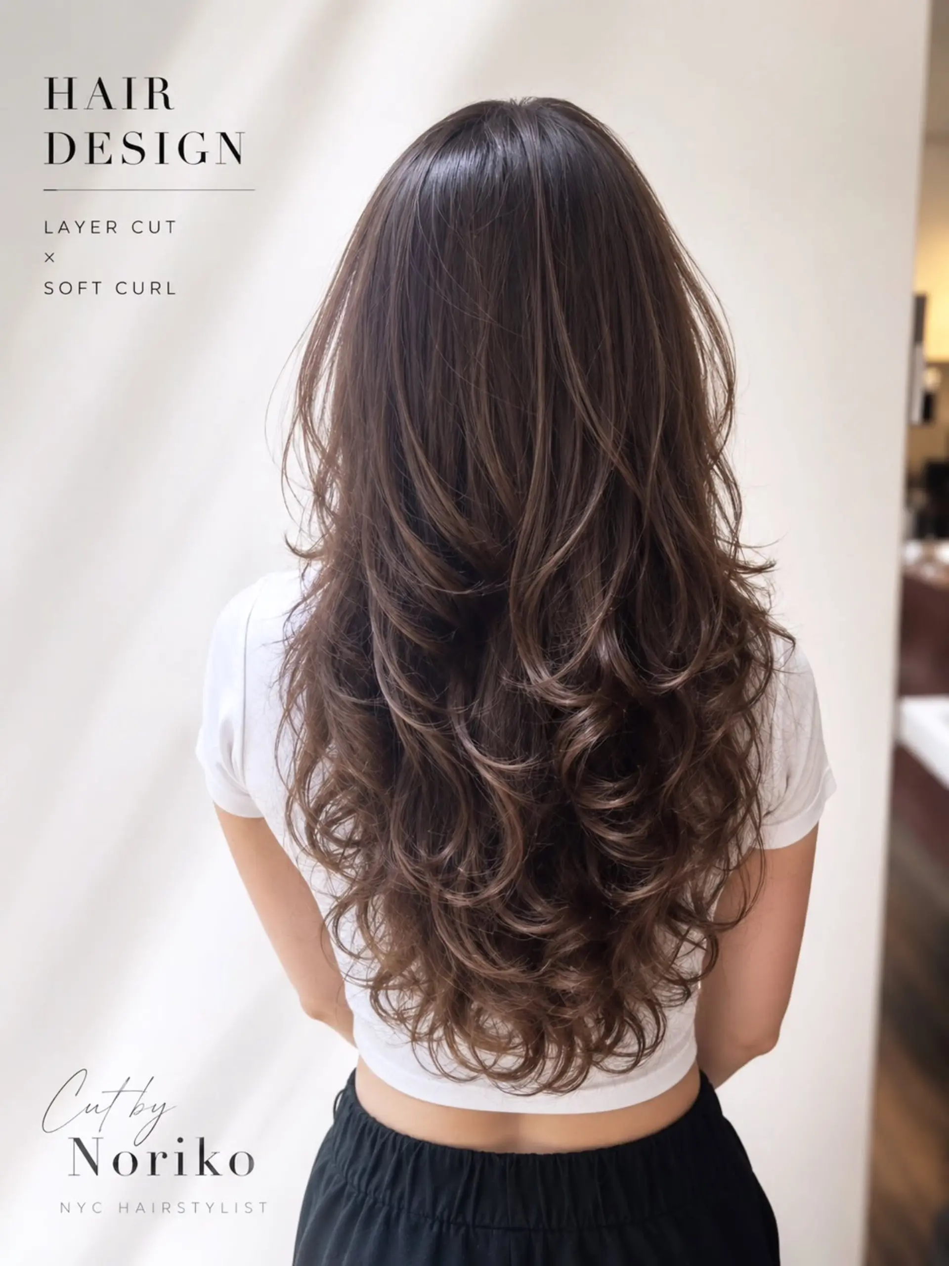 Long brown hair cut into cascading butterfly layers and styled into soft, voluminous curls. 1