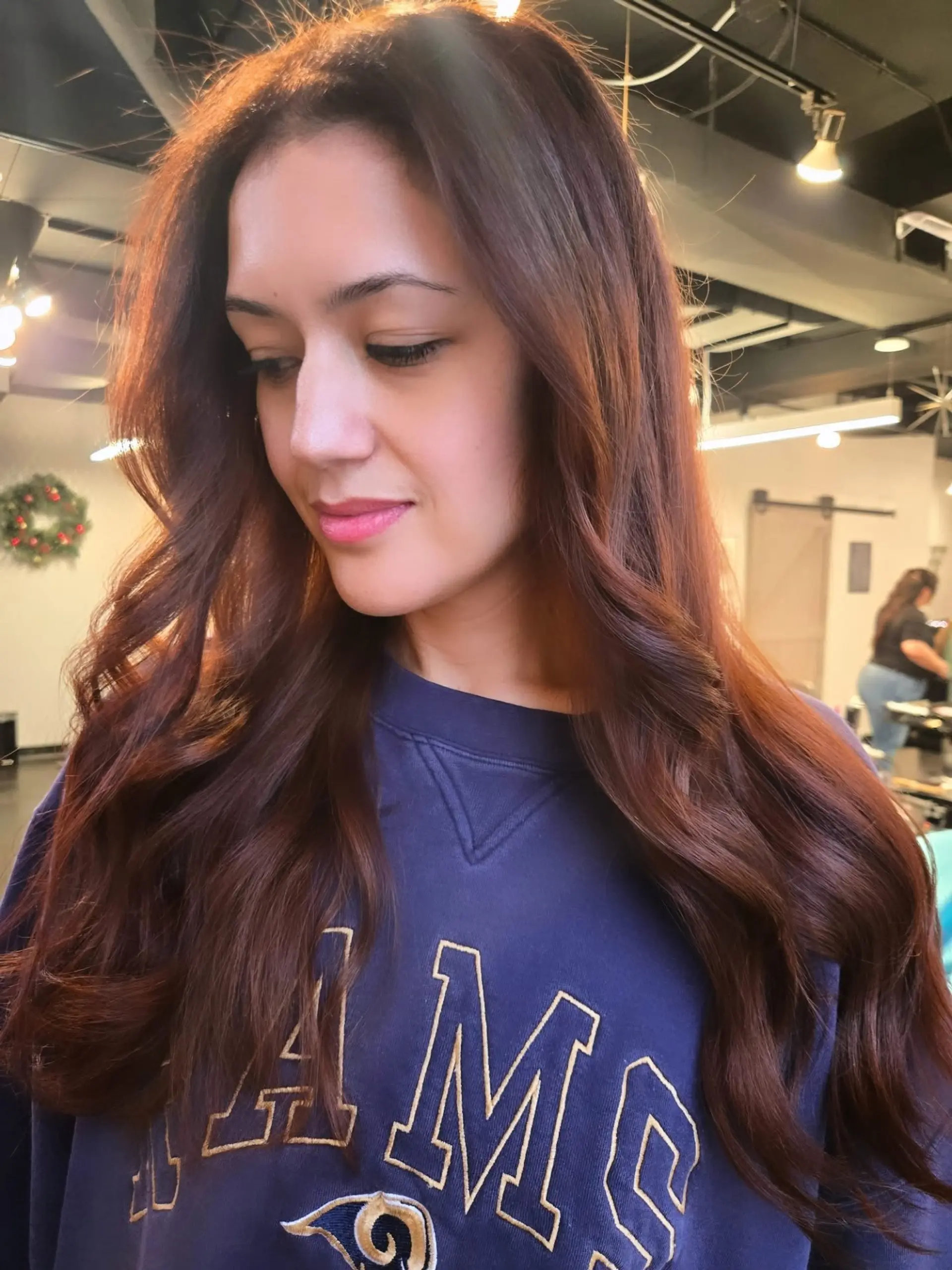 Rich auburn and warm brown hair styled in soft, loose waves with a glossy blowout finish. 1