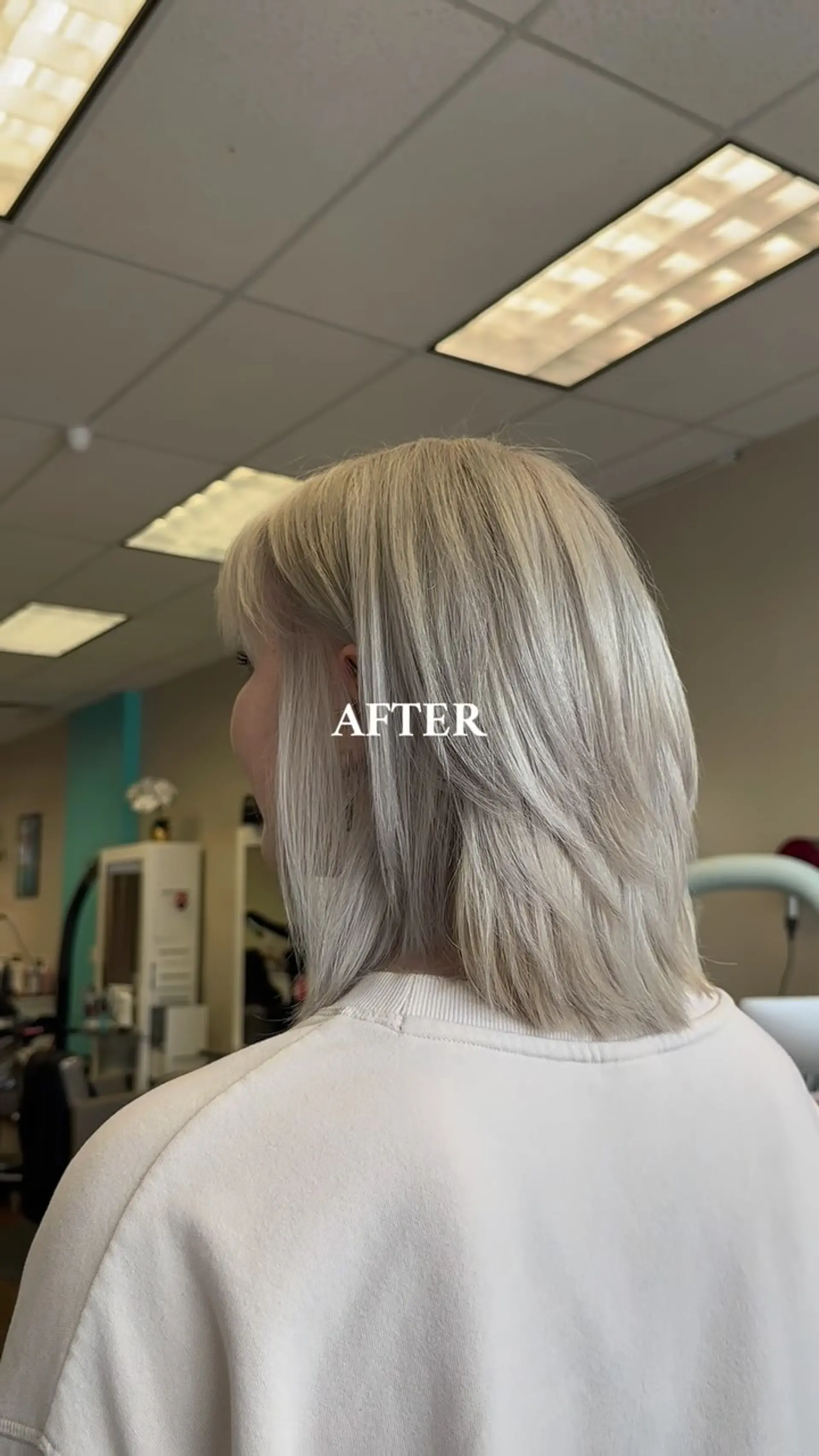 A textured medium-length layered cut in cool-toned platinum blonde styled smooth and straight. 1