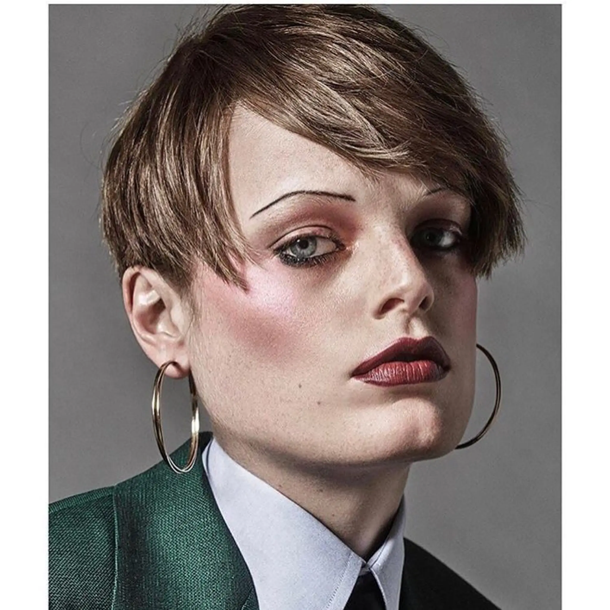 A short, straight haircut with a modern asymmetrical fringe, featuring smooth texture and subtle layers in a glossy brown hue.