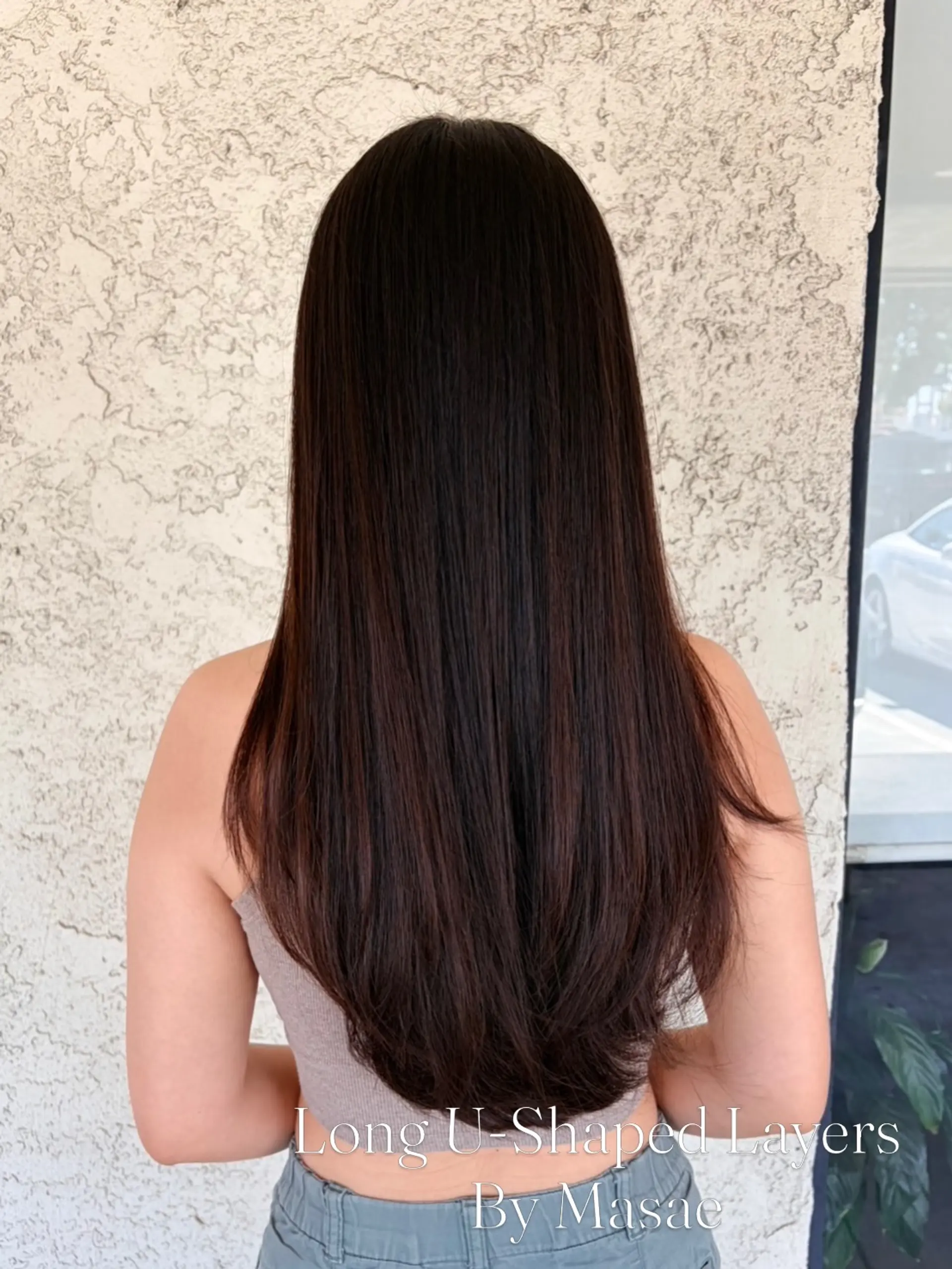 Straight, smooth dark hair cut into soft long layers forming a classic U-shape silhouette at the back. 1