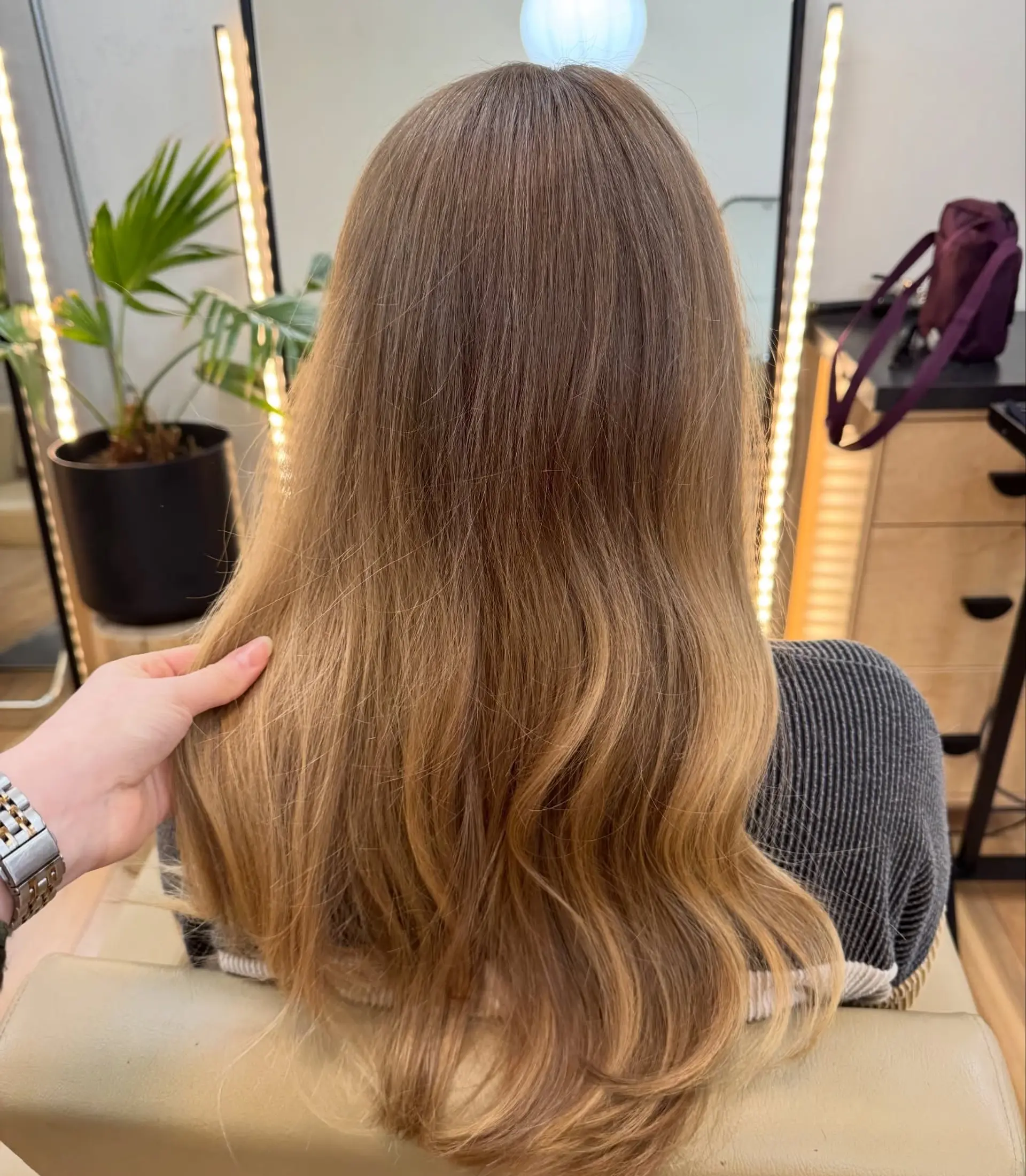 Long warm honey blonde balayage styled with soft, natural waves. 1