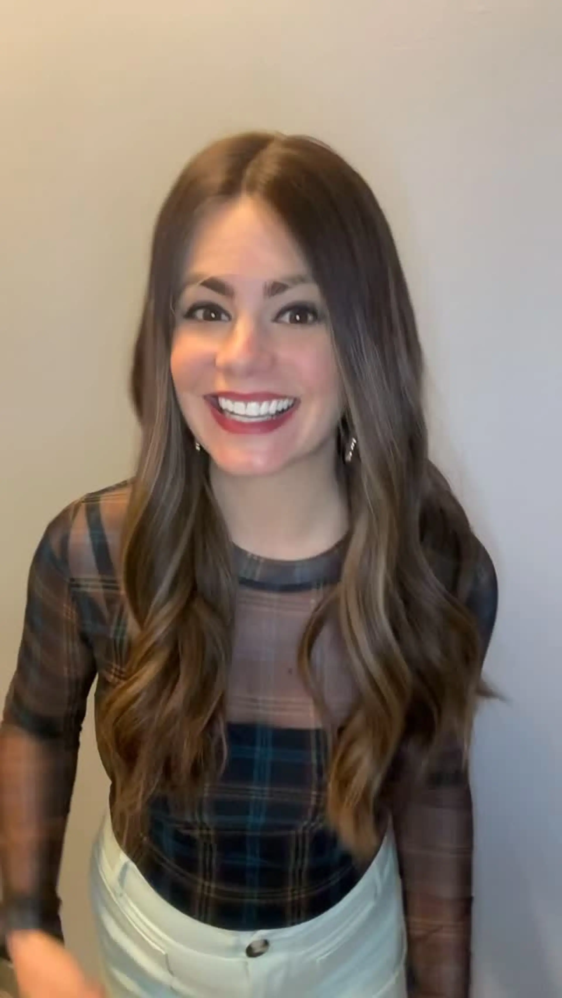 Long dimensional brunette hair parted down the center and styled into soft, flowing waves. 1