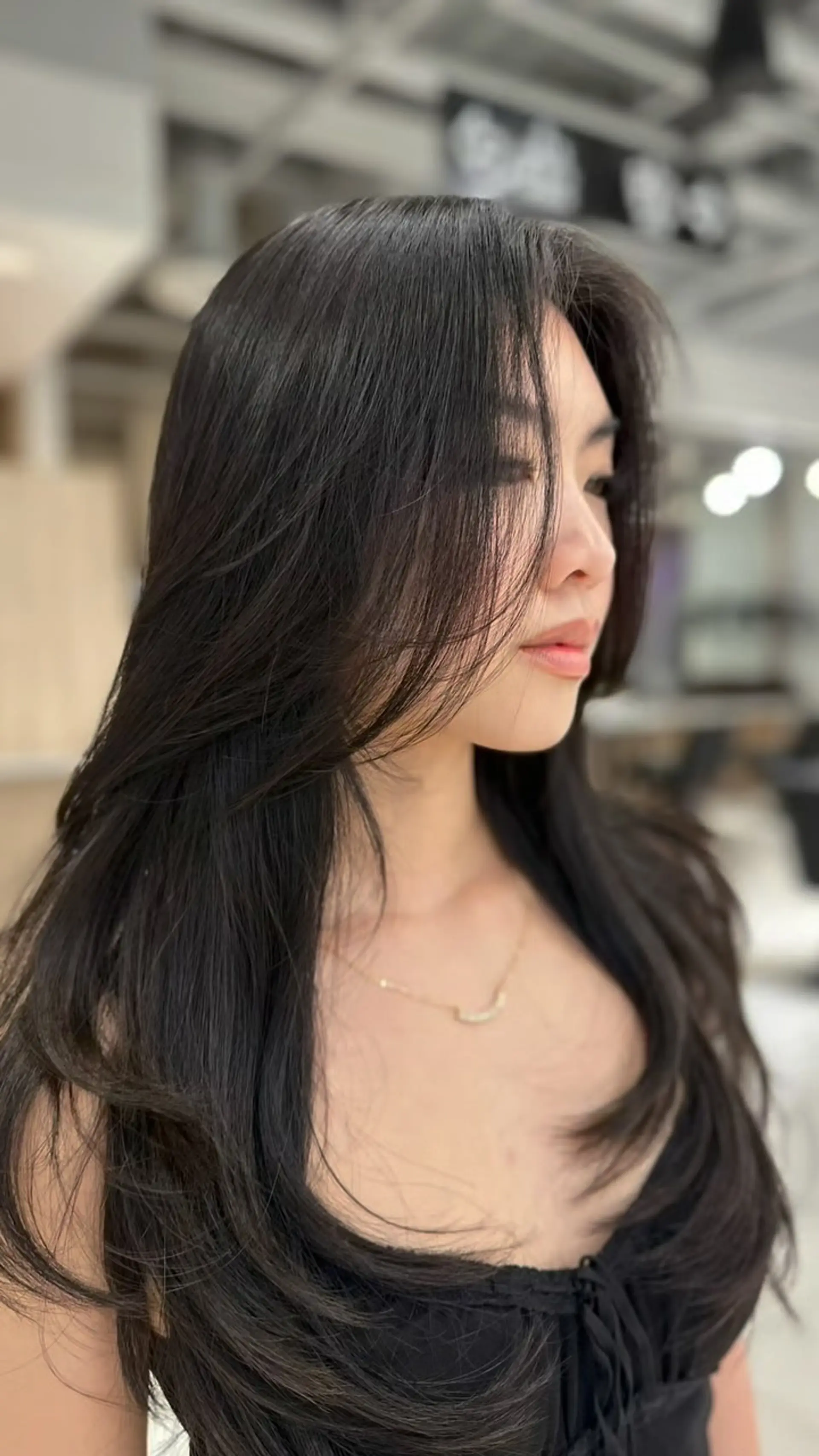 Long black haircut featuring soft, fluid layers and face-framing curtain layers. 1