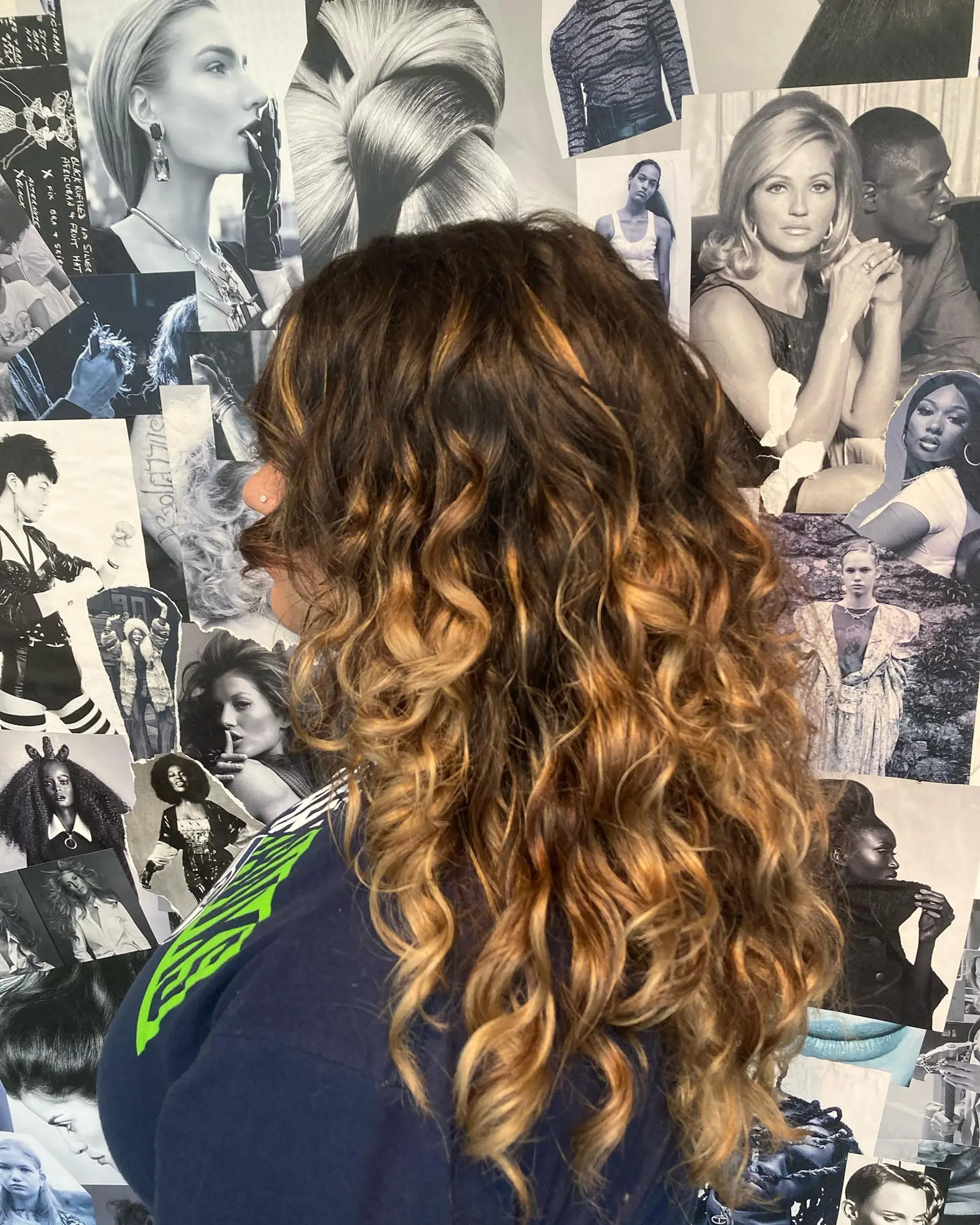 Defined long curls enhanced with a seamless foiliage balayage blending dark brown roots into warm caramel and golden blonde ends. 1