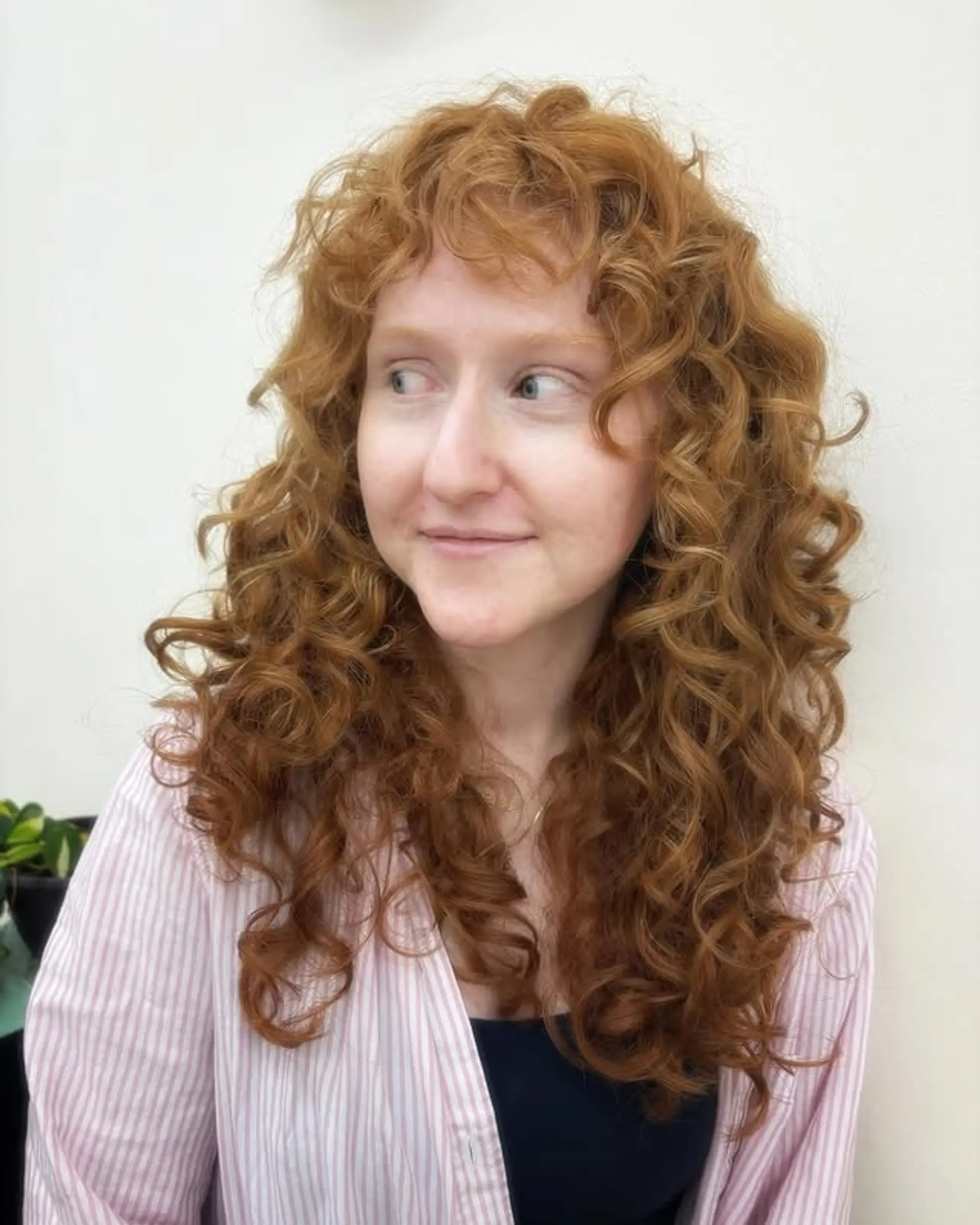 A copper-colored, medium-length curly shag with curly bangs. 1