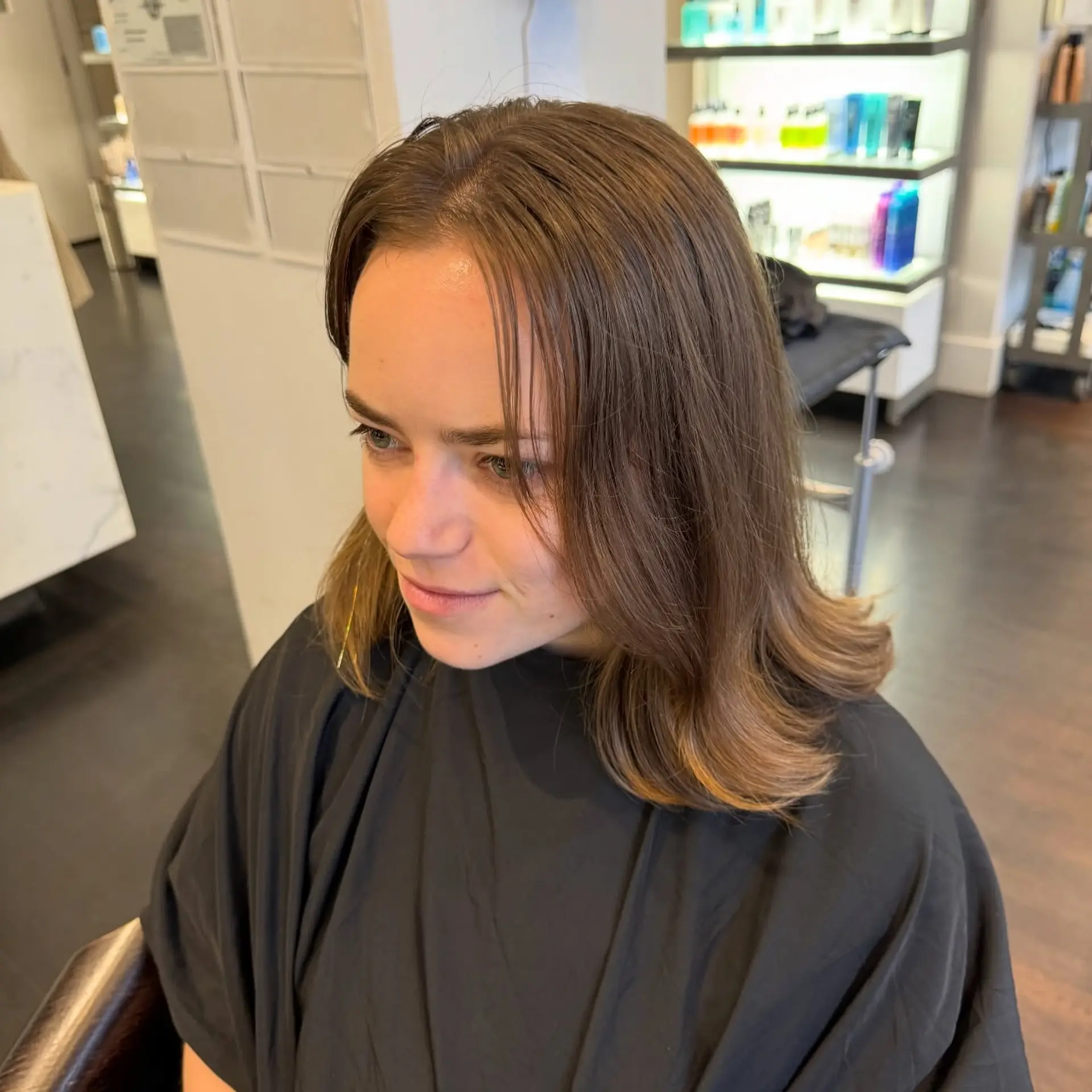 A shoulder-length warm brown lob styled straight with softly flipped-out ends and curtain-style face-framing strands. 1