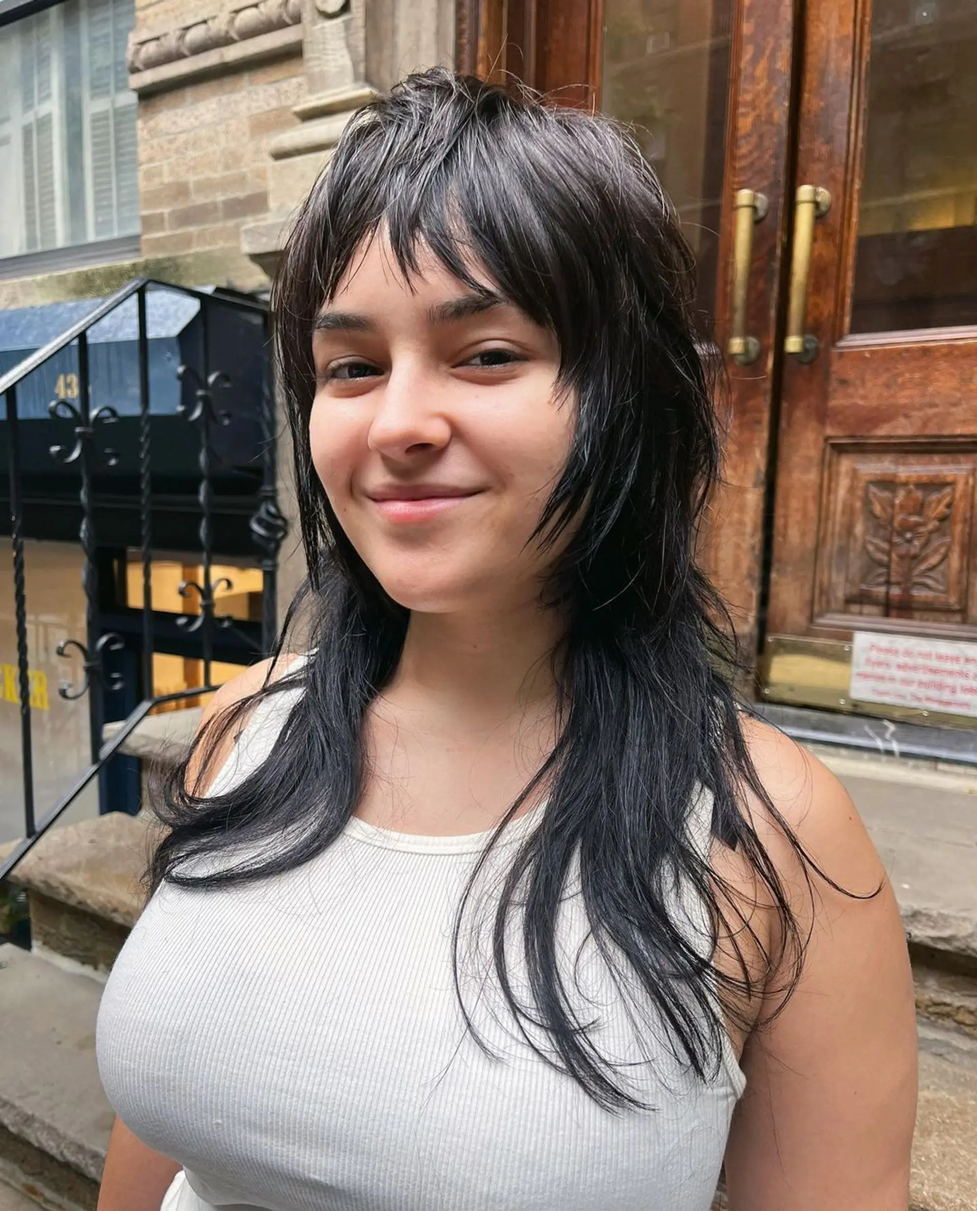 The Edgy Layered Mullet features long, black wavy hair styled into distinctive layers with a choppy, feathered fringe in the front. This modern take on the classic mullet includes edgy, uneven cuts that exude a rock-and-roll vibe. 1