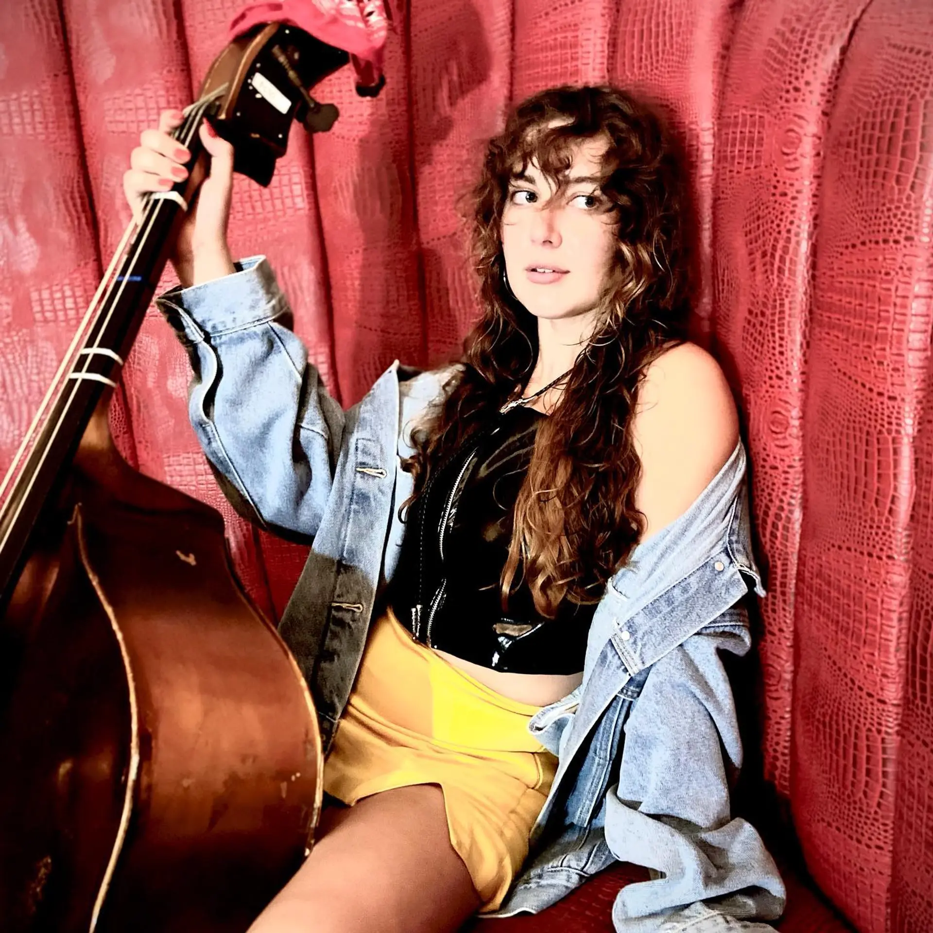 Long, layered curly hair with bangs and subtle balayage. 1