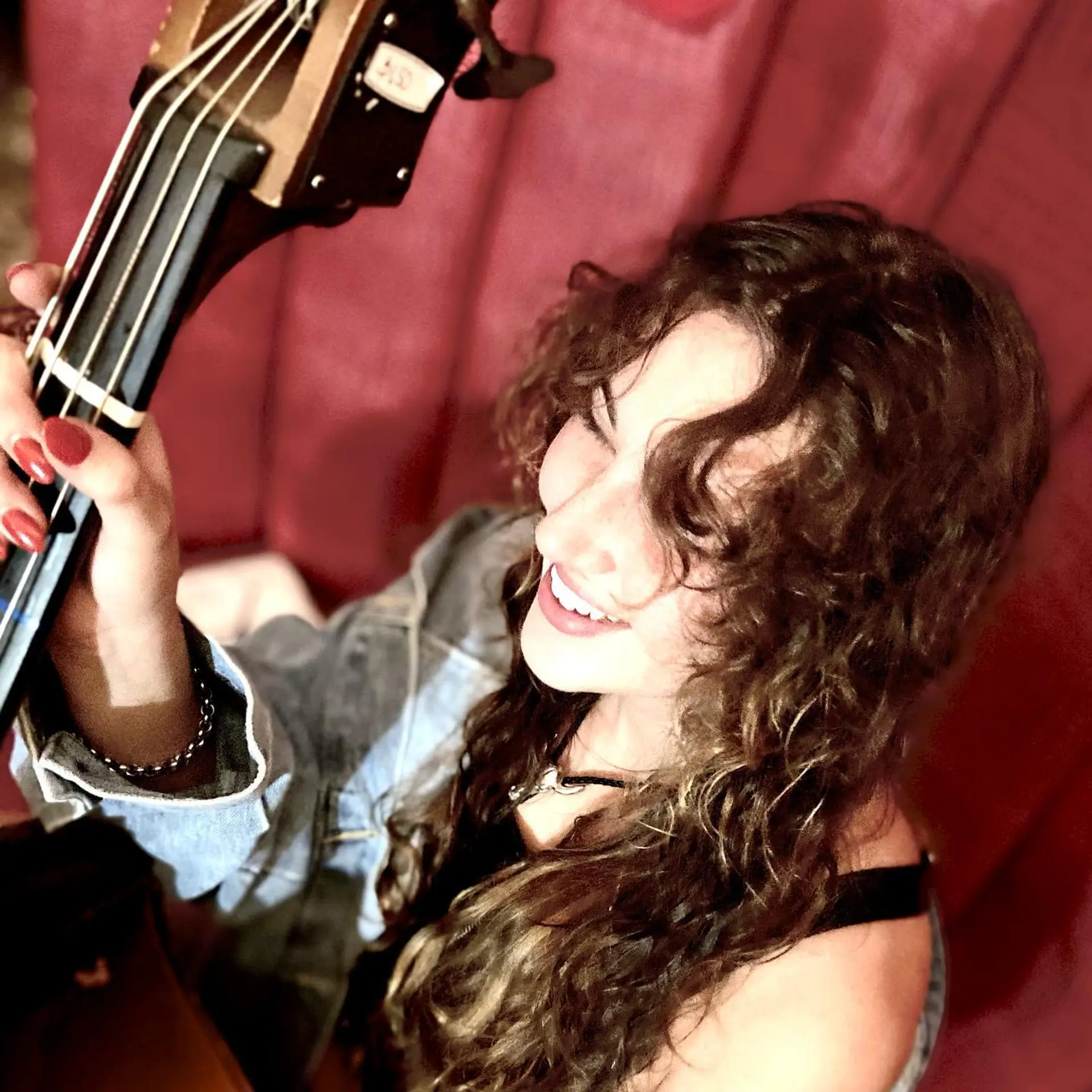 Long, layered curly hair with bangs and subtle balayage. 4