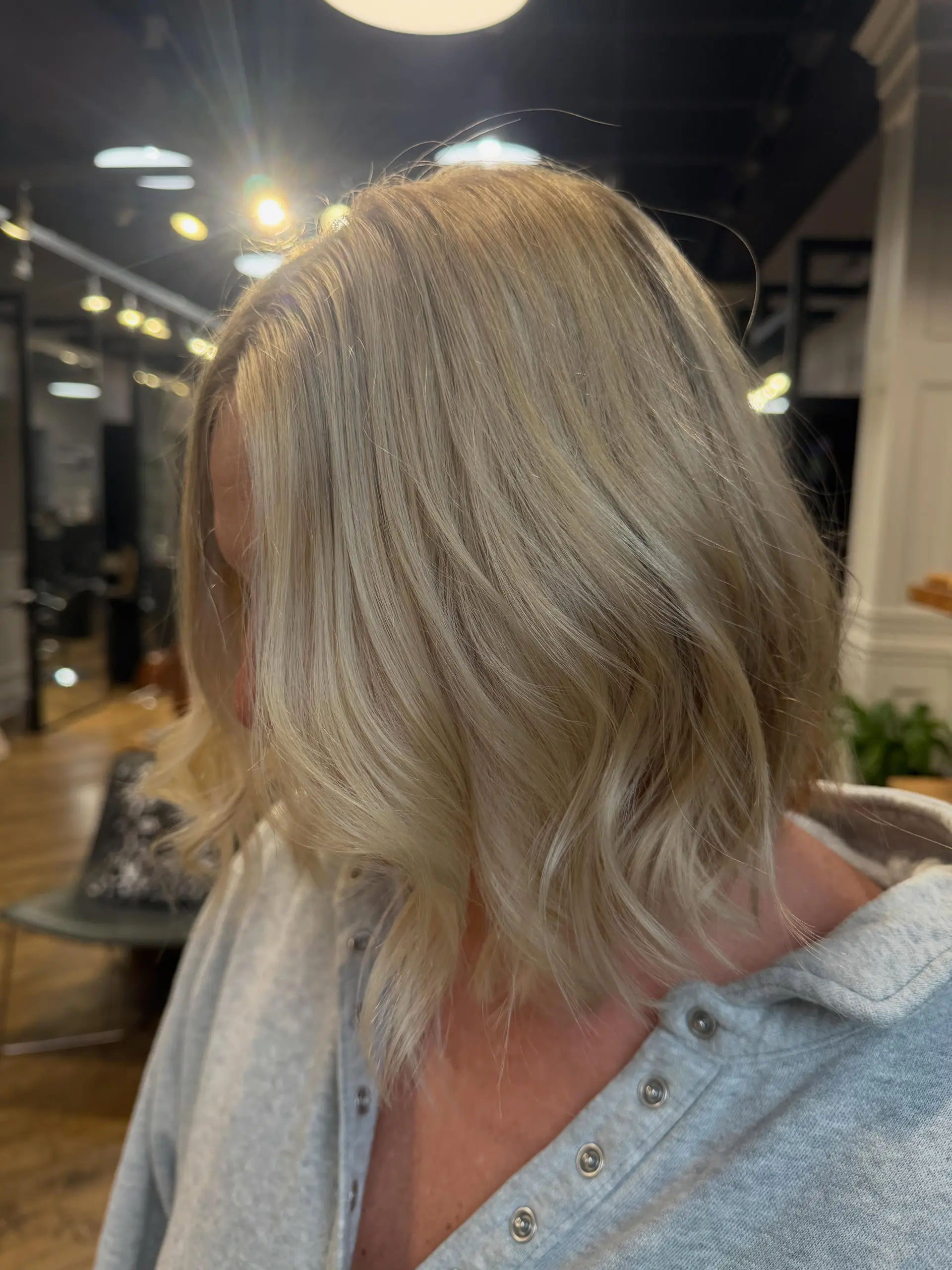 A textured, collar-length bob styled with soft waves and bright, multi-tonal blonde highlights. 1